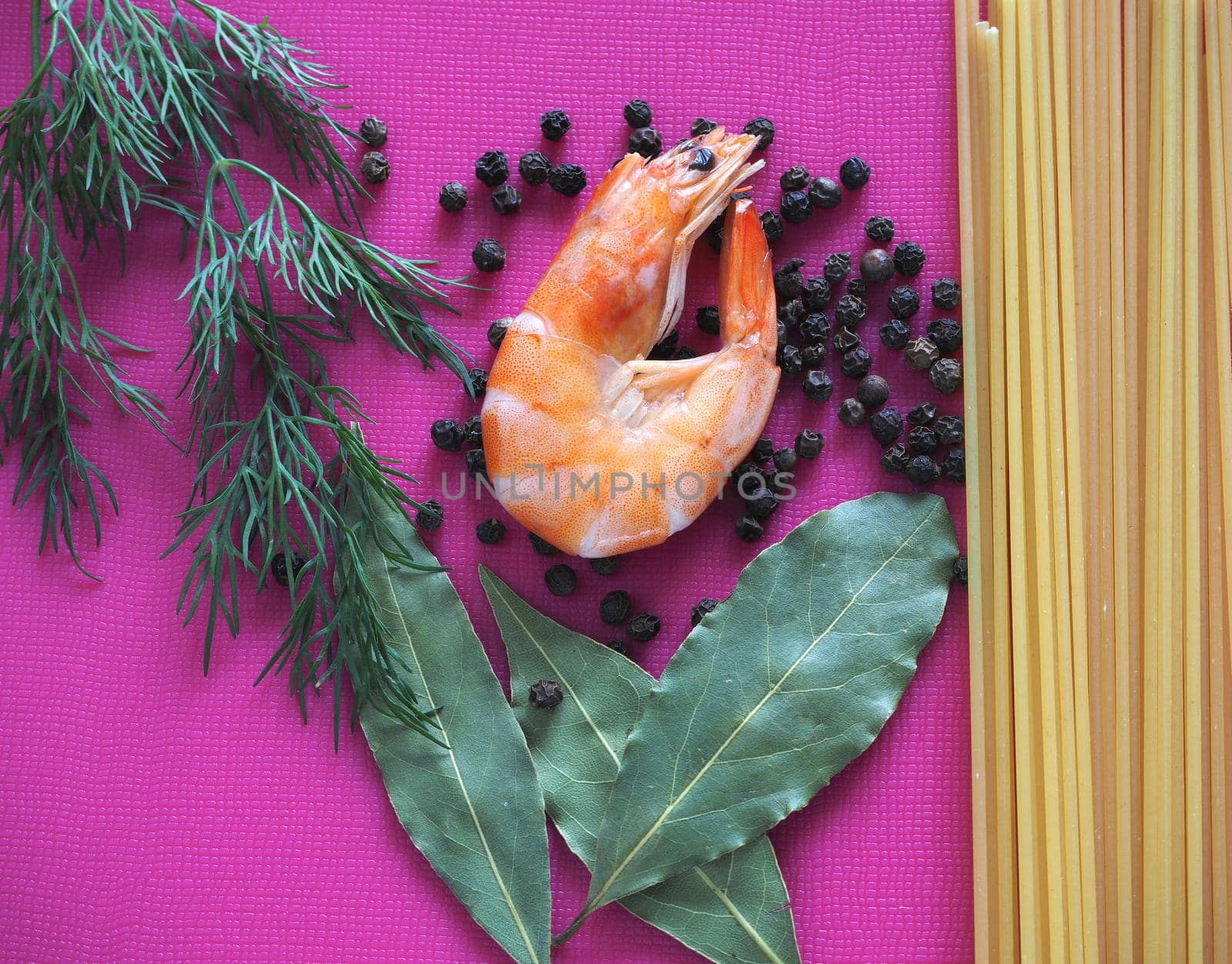 Large prawns with spices and spaghetti. Prawns with dill and pepper close-up. Bright background.