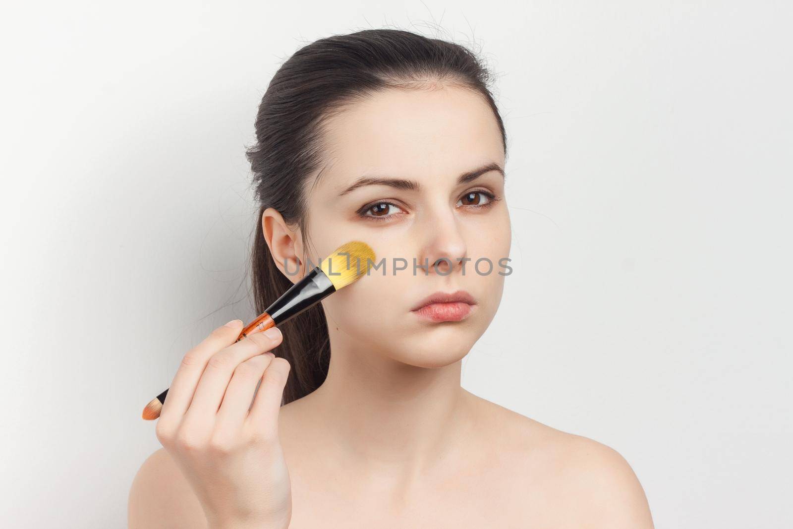 woman with bare shoulders loose hair clean skin sponges in hands. High quality photo