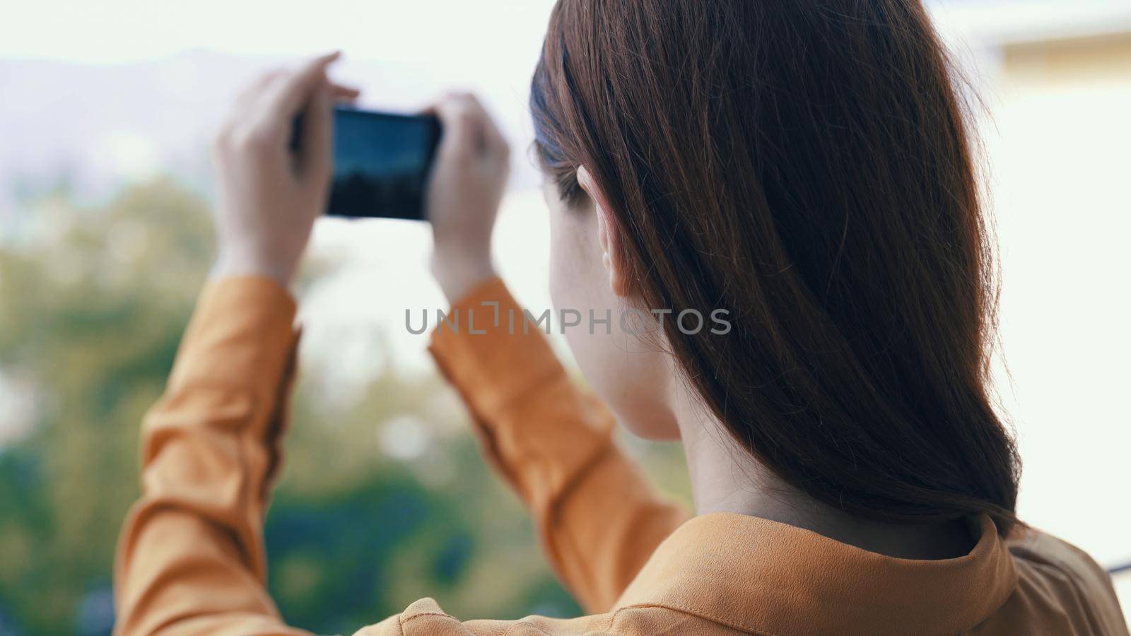 woman outdoors with a phone in her hands takes pictures on camera. High quality photo