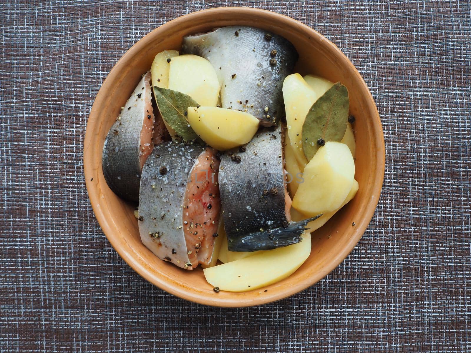 The dish of fish with vegetables is raw. Close-up.