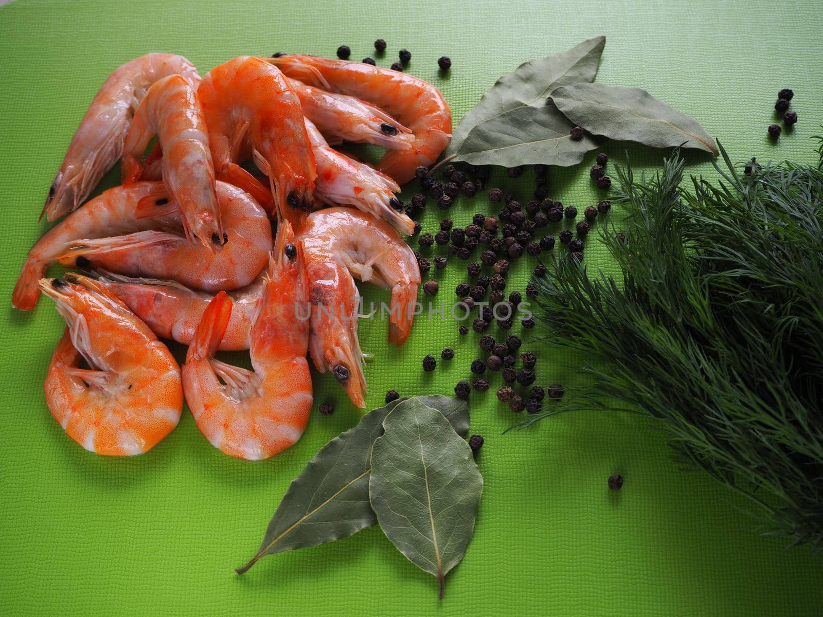 Prawns are royal with herbs and spices on a green background. Close-up.