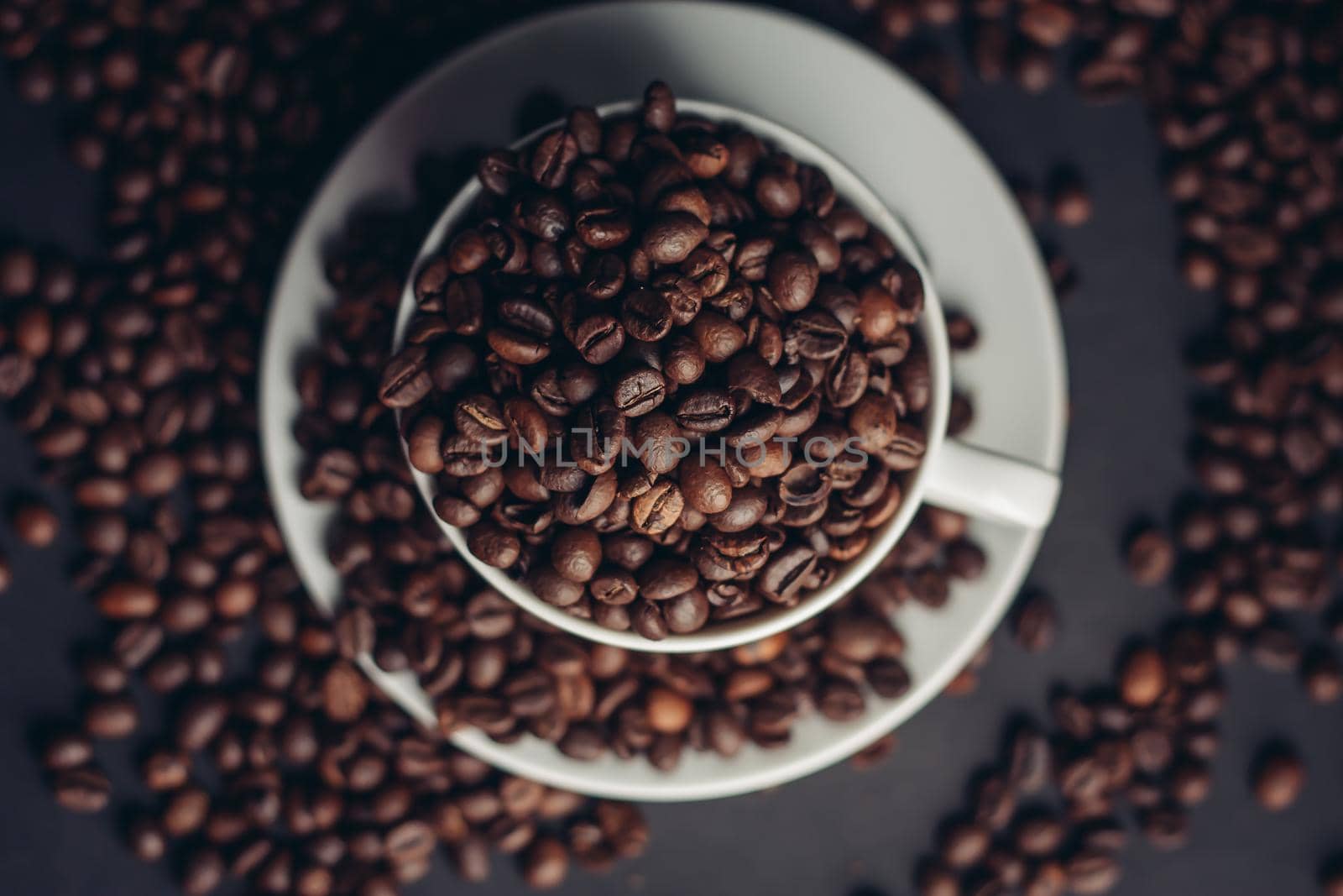 coffee beans in a cup and white saucers gray background close-up. High quality photo