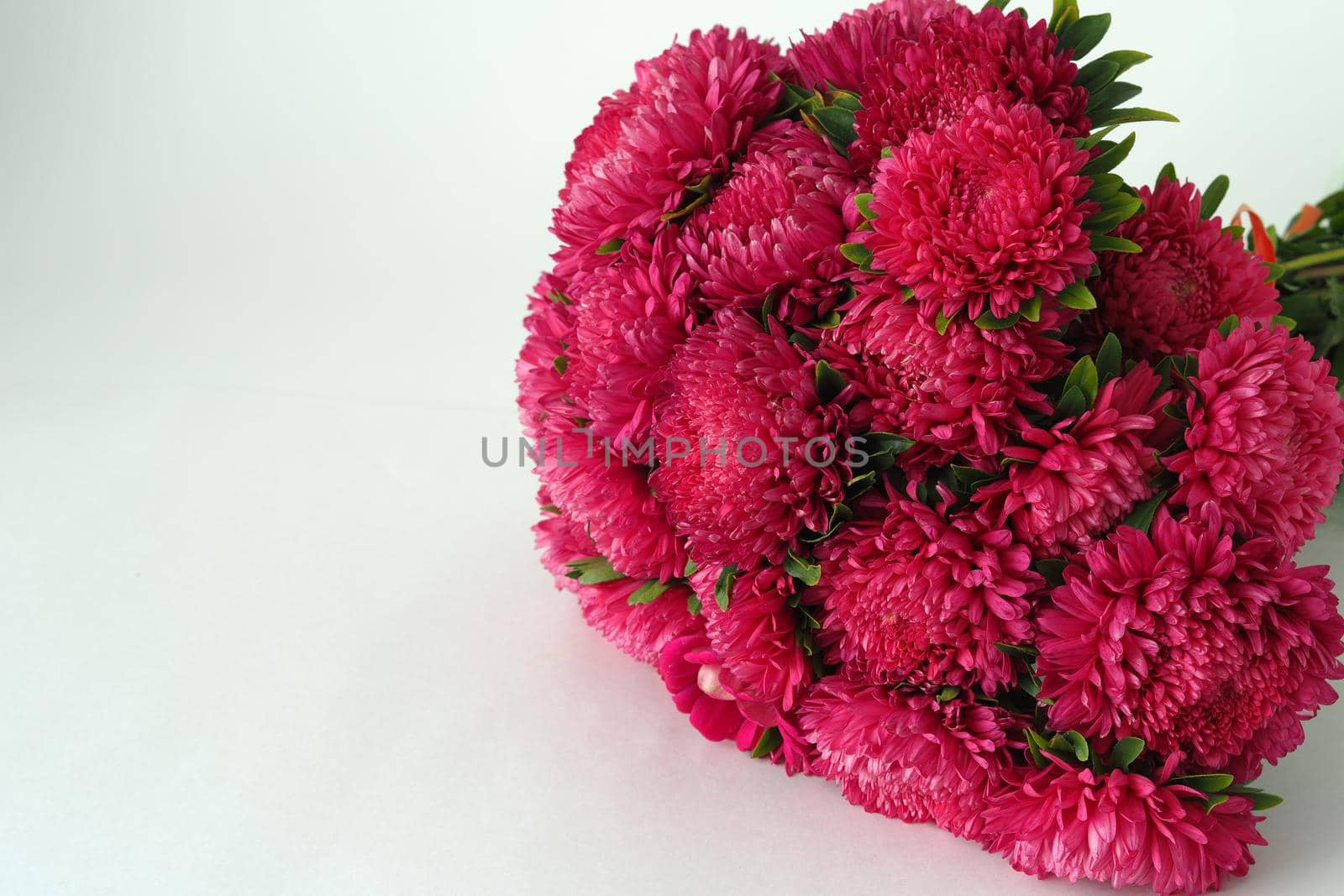 Bouquet of flowers. Asters are pink. Close-up, on a white background.