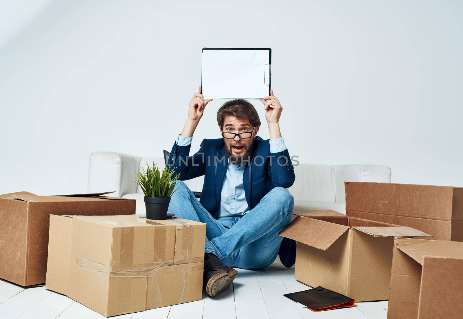Emotional Man sits on the floor next to boxes unpacking a move Professional. High quality photo