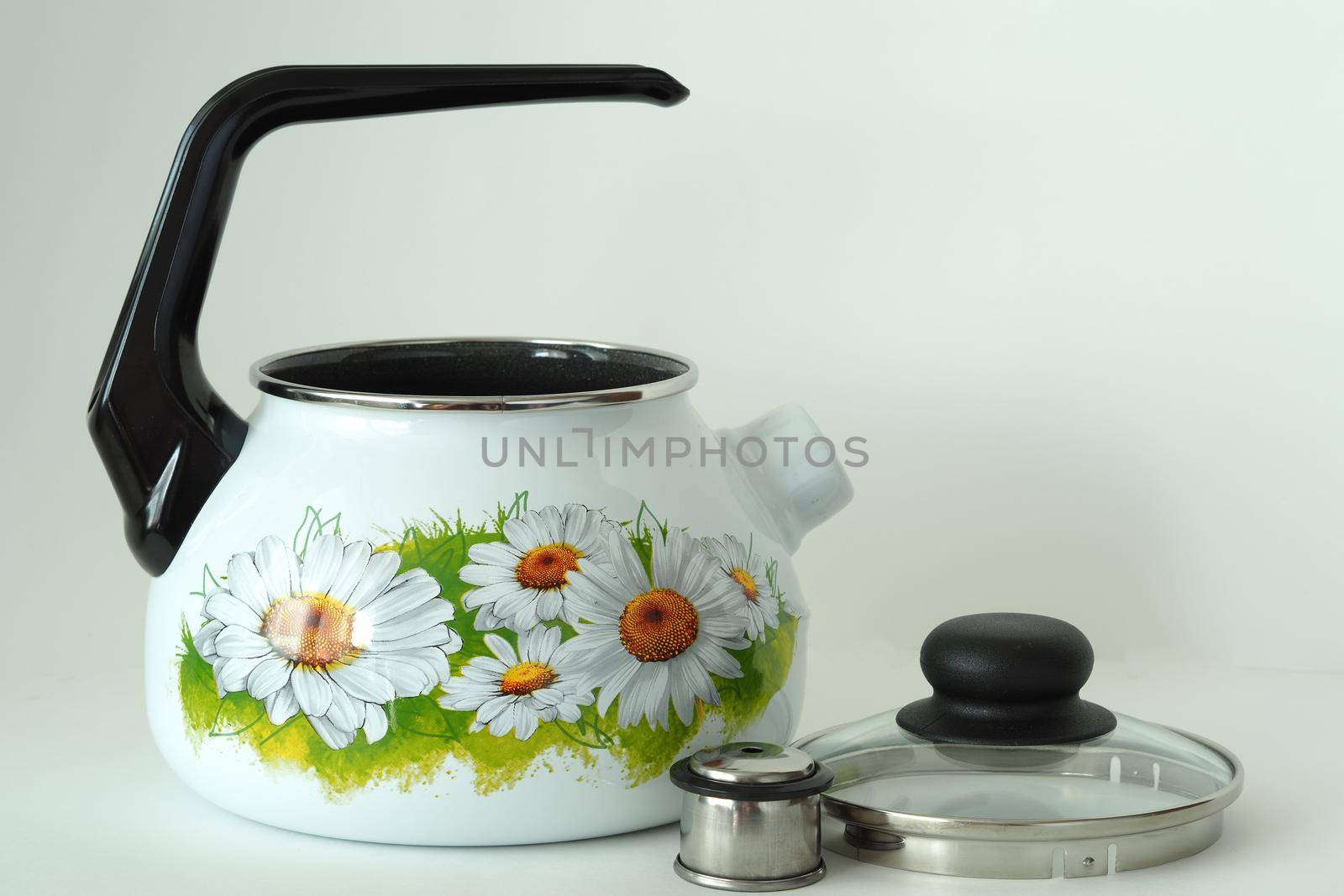 The kettle is enamelled white with a whistle and pattern. by Olga26