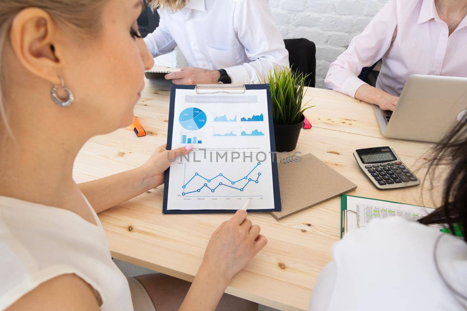 Diverse executive business people team discussing work results at meeting, multiracial businessmen talking analyzing financial statistics report sitting together in modern office