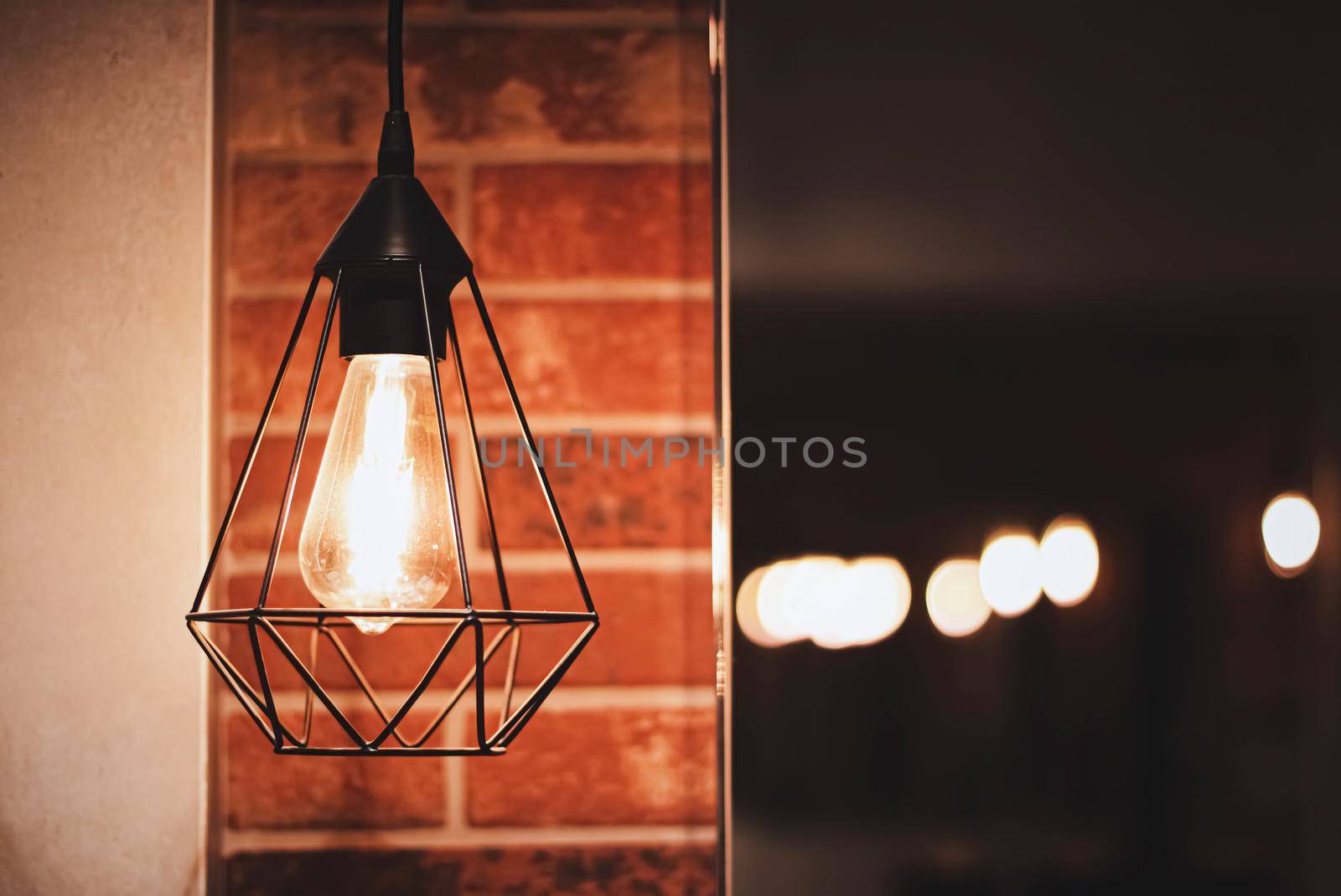 Pendant industrial lamps in loft interior with dark brick walls, modern design and home decor concept