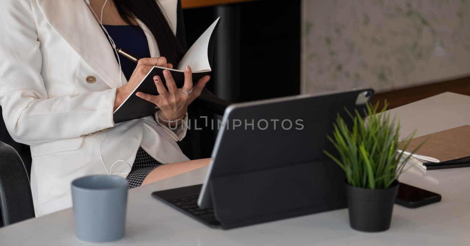 Woman with video conference note some data on notepad for protection covid-19.woman using tablet webinar video course at home office.- education or business online concept.