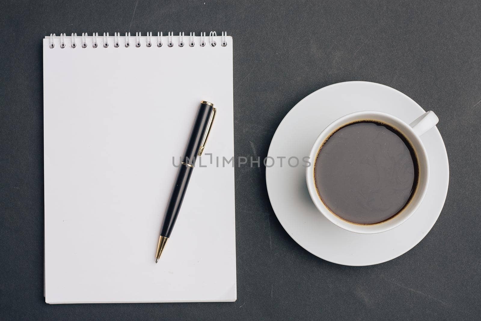 the dark background a Cup of coffee office Notepad handle the view from the top. High quality photo