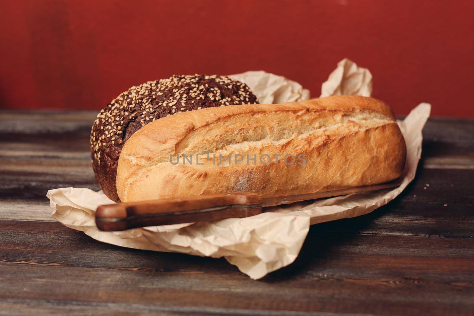 flour products rye bread on packaging and wooden table knife red background. High quality photo