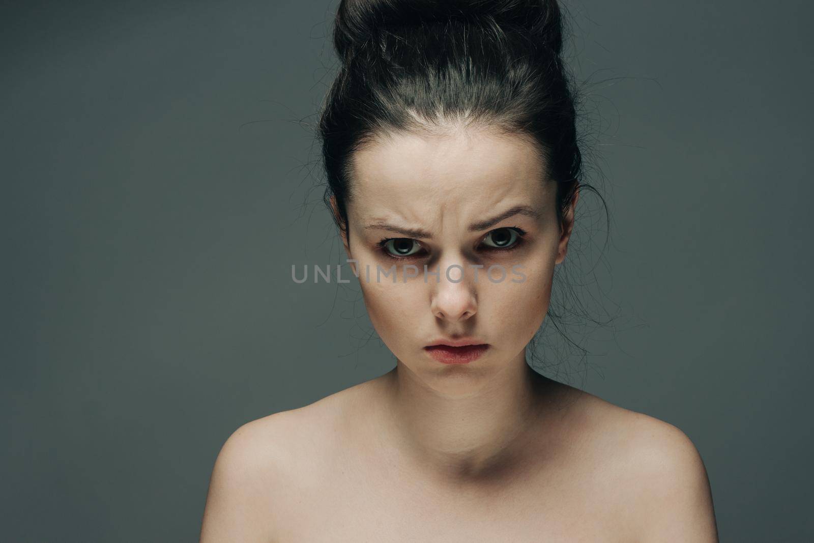 emotional brunette with bare shoulders close-up portrait cropped view. High quality photo