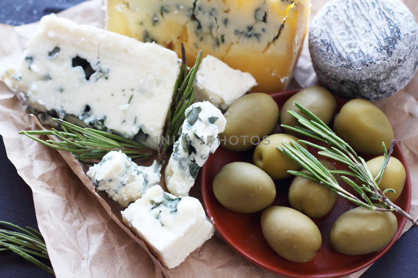 Roquefort cheese and olives gourmet stylish composition on dark background