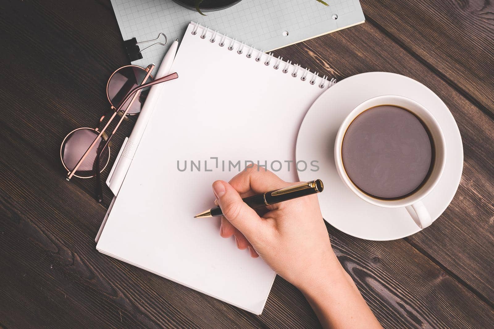 notepads ballpoint pen on table coffee cup potted flower office work freelancer. High quality photo