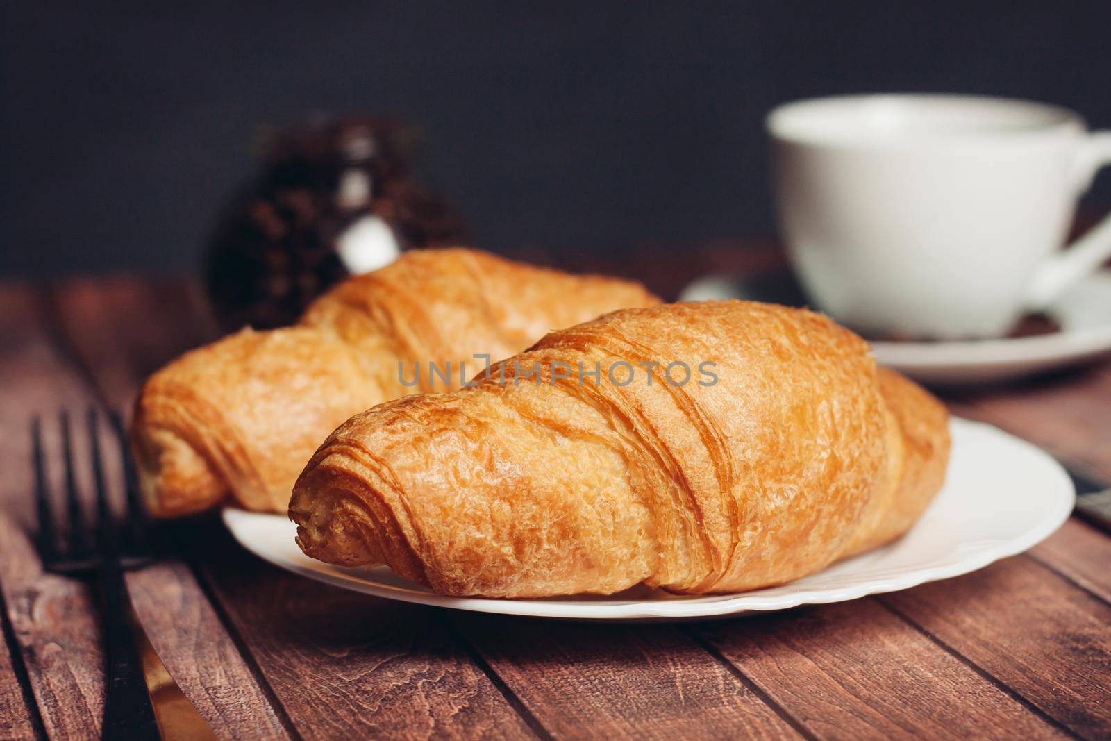 crispy croissants on a plate kitchen utensils for breakfast meal dessert. High quality photo