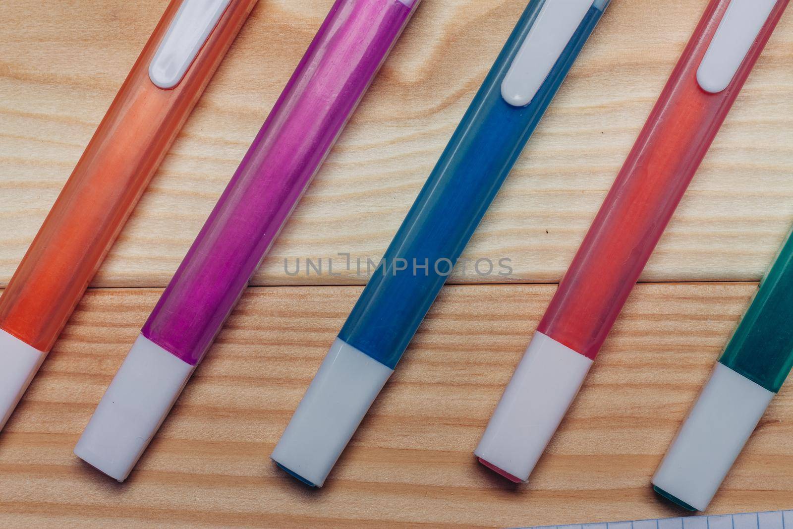 multicolored markers work desk close-up wooden background office. High quality photo
