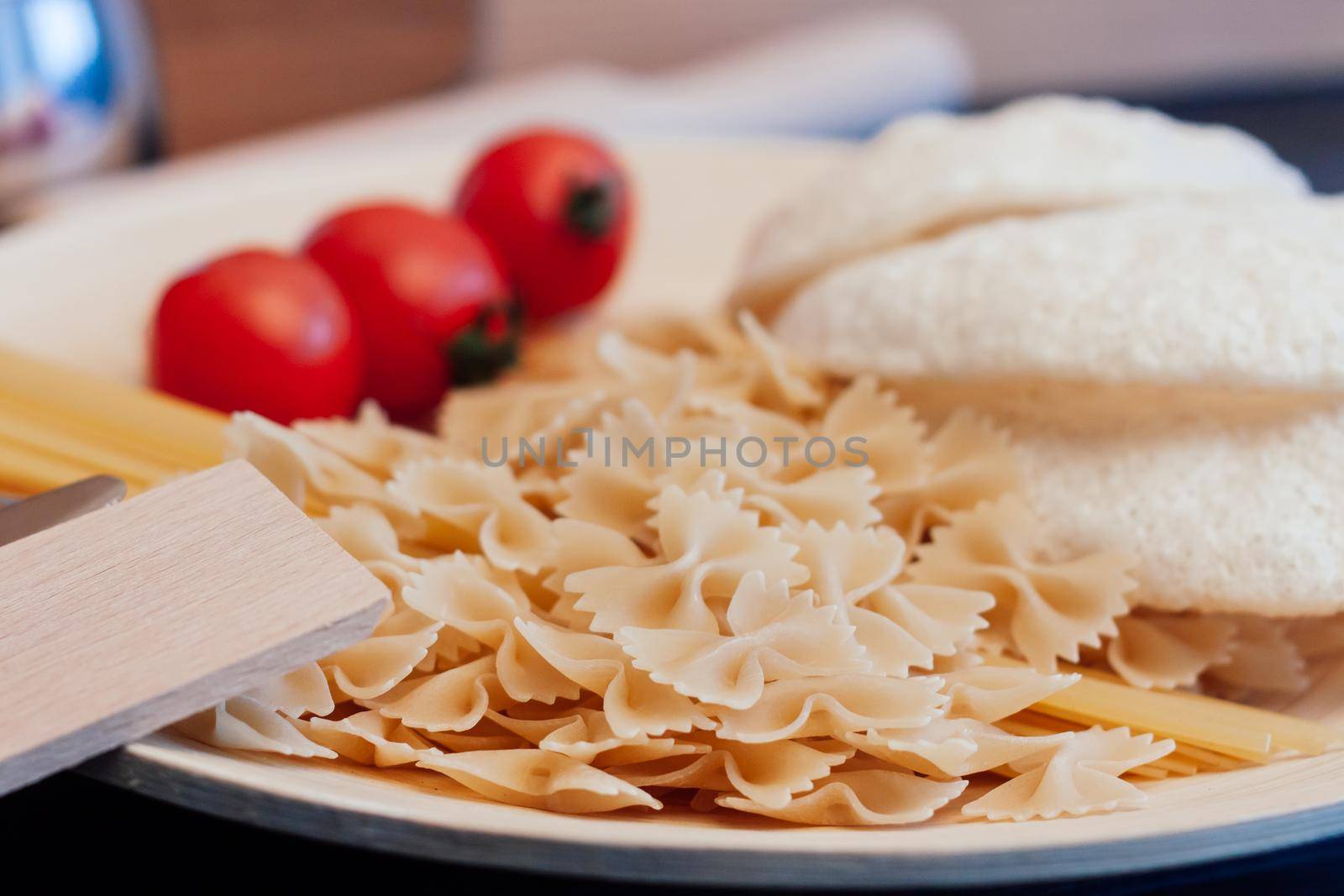 italian pasta cherry tomatoes cutting board food preparation. High quality photo