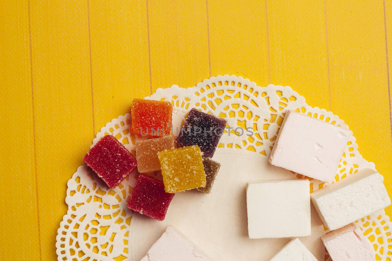 marmalade multicolored candy chocolate sweets dessert on a yellow background. High quality photo