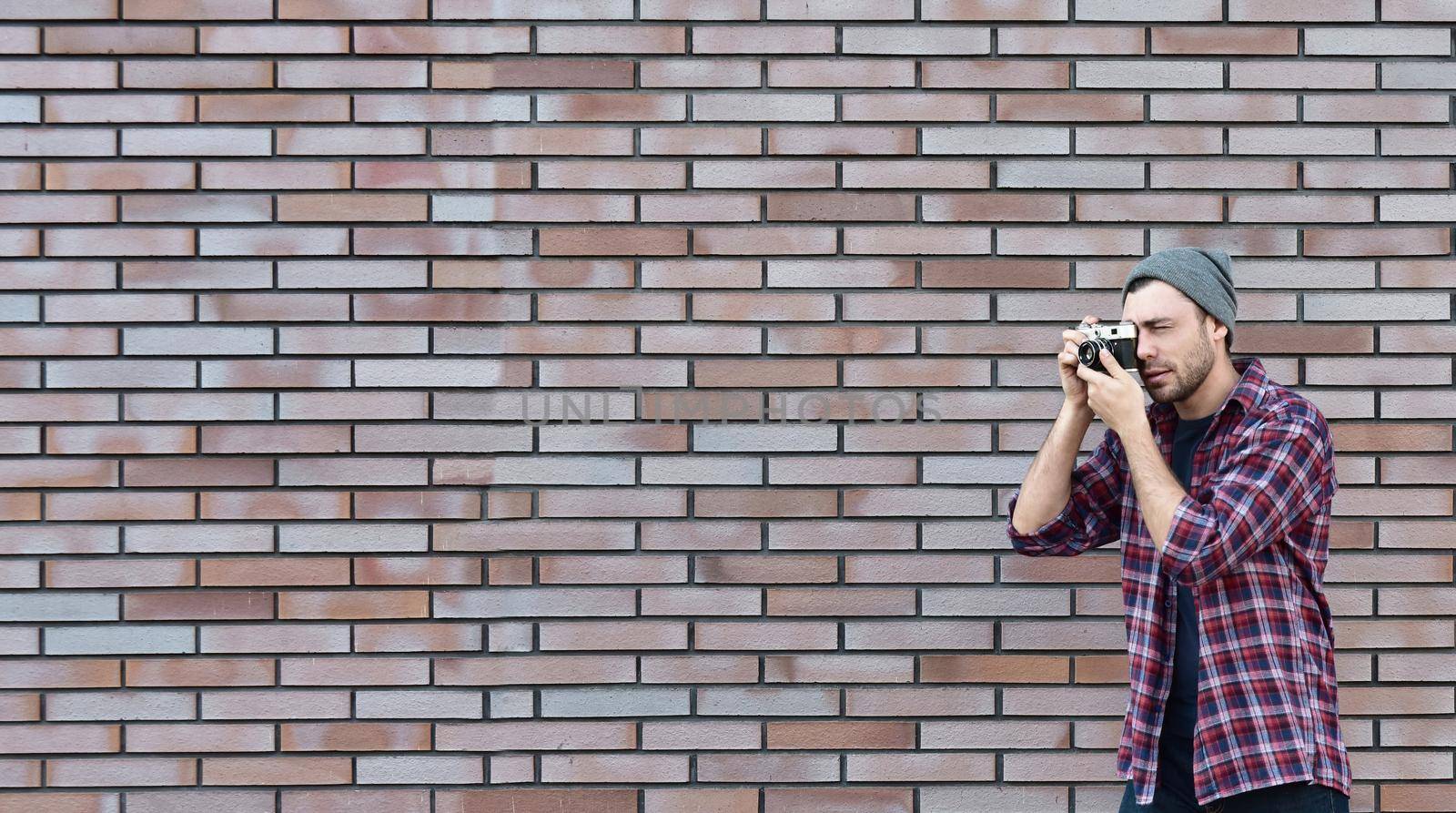 Say cheese, hipster fashion photographer man holding retro camera by Nickstock