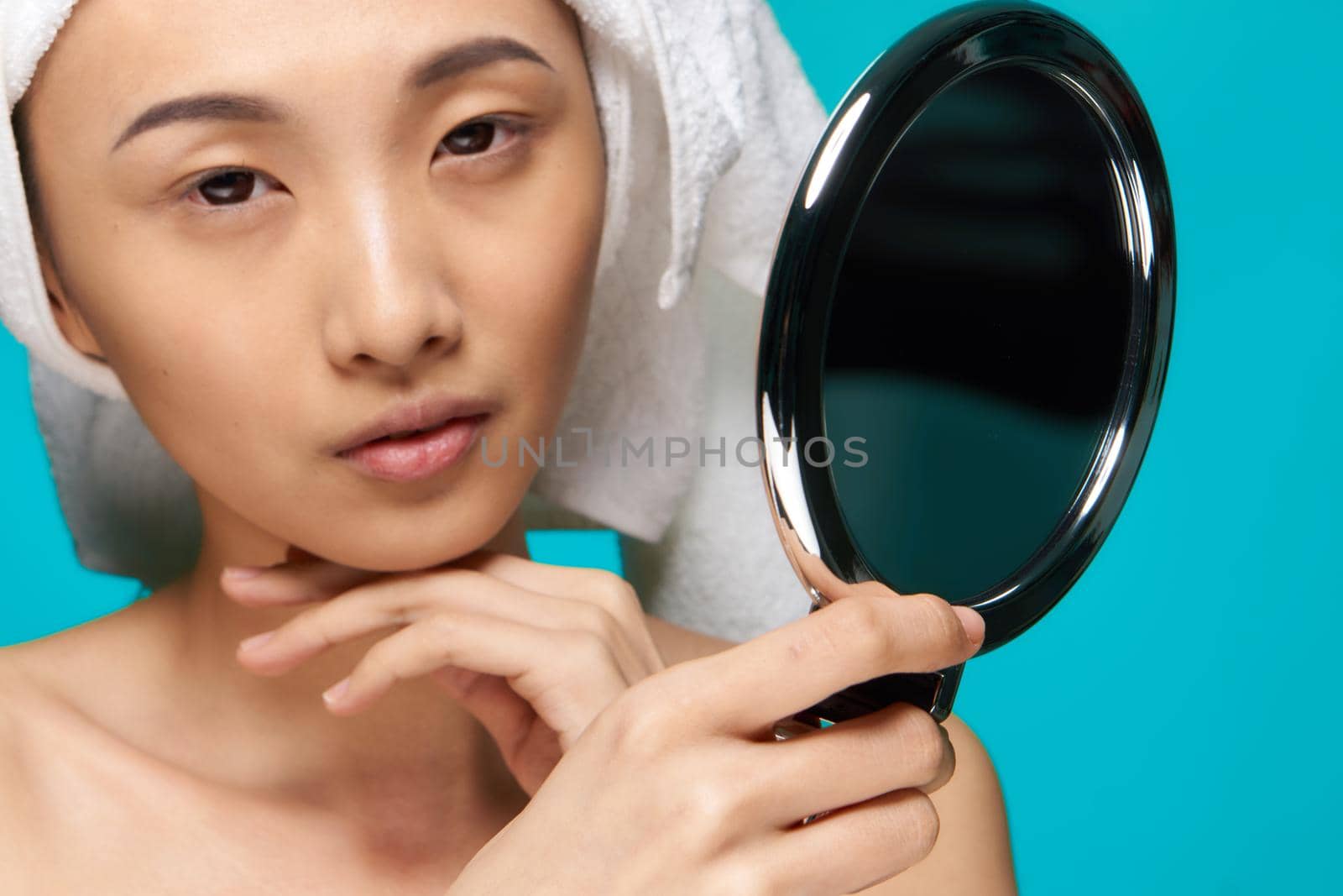 pretty asian woman looking in mirror naked shoulders clean skin after shower. High quality photo