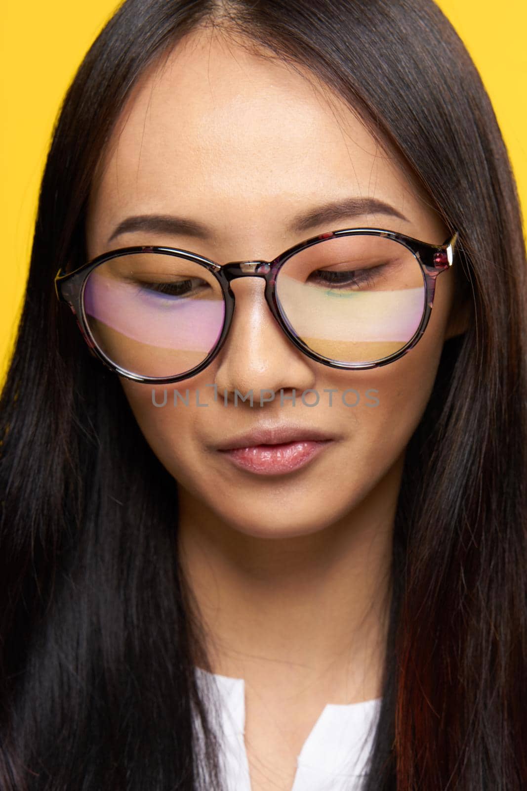 asian woman with glasses student close-up yellow background. High quality photo