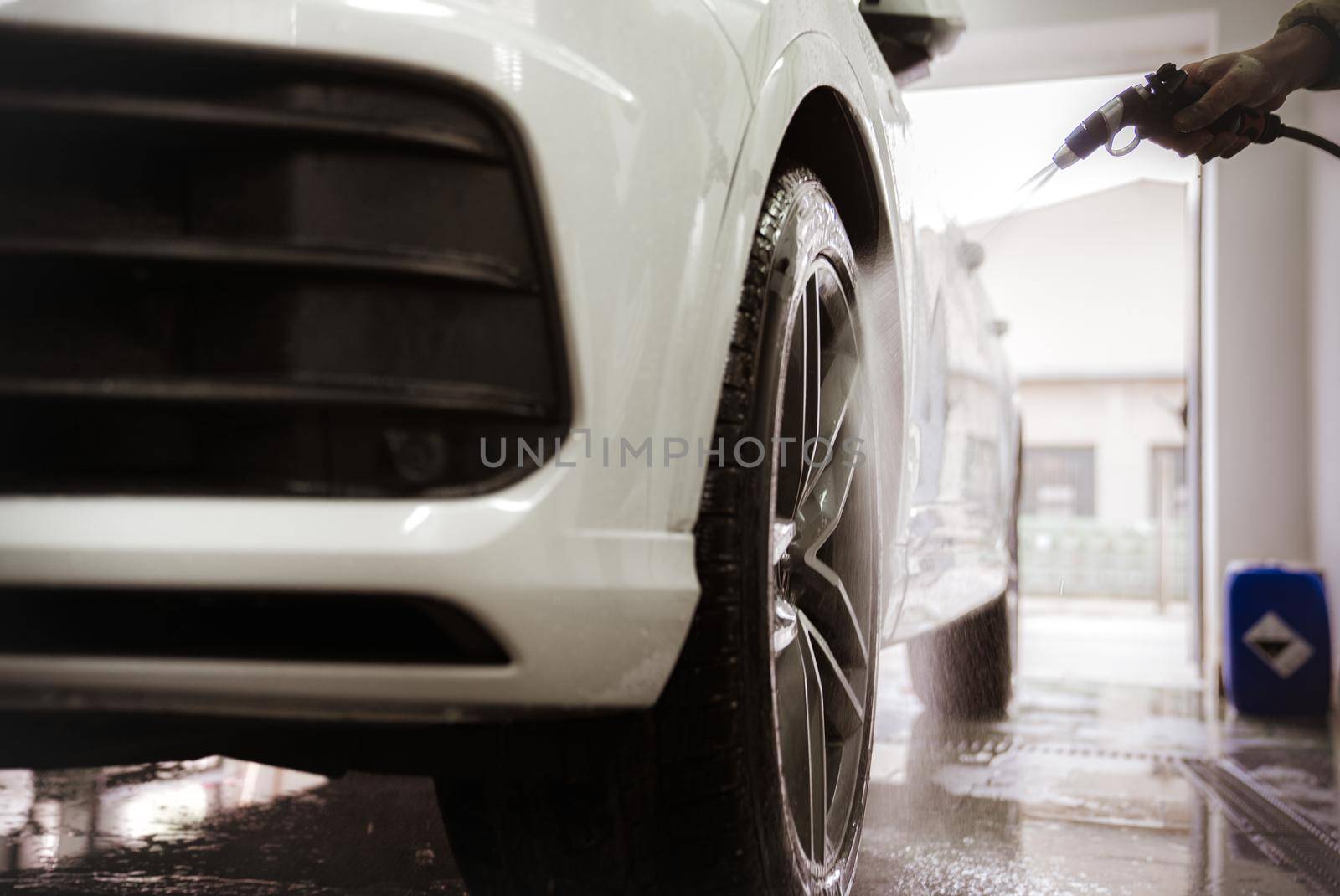 manually wash car wheels using pressure hoses with water.