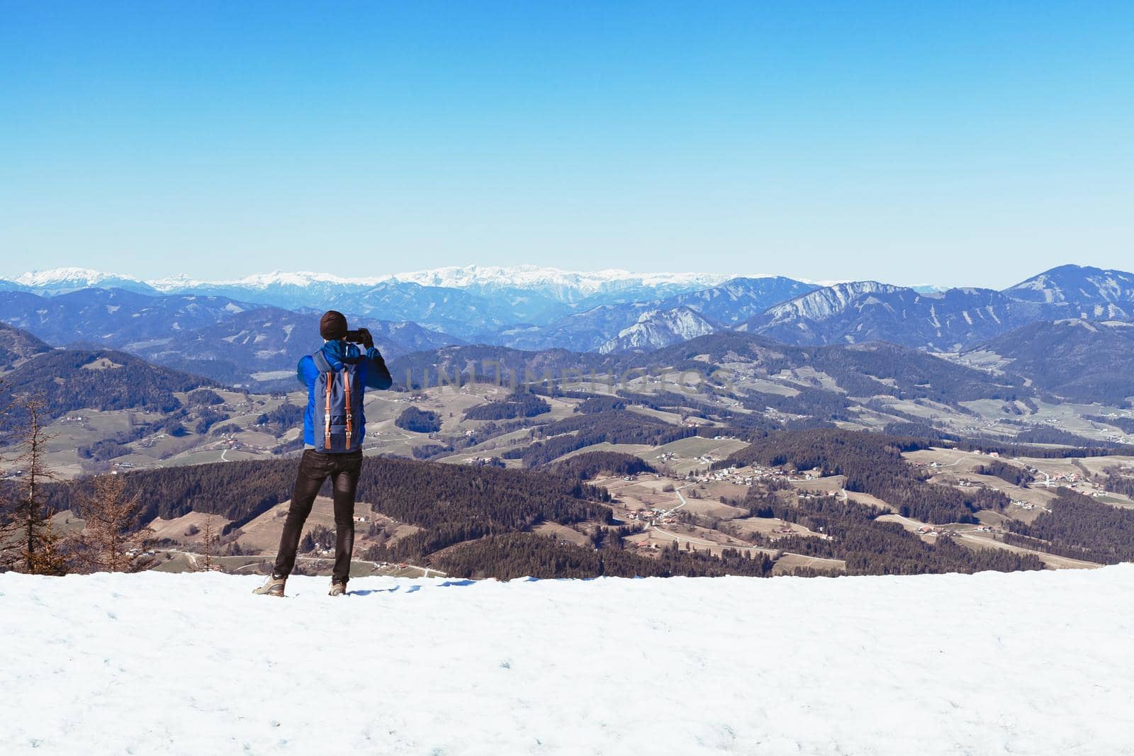 hiker on the top of the mountain takes pictures on his smartphone by Edophoto