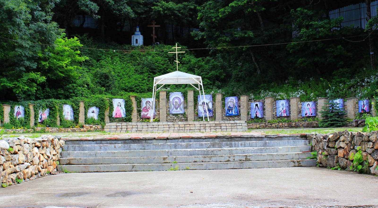 An Orthodox exhibition of outdoor icons on the grounds of a monastery in the forest.