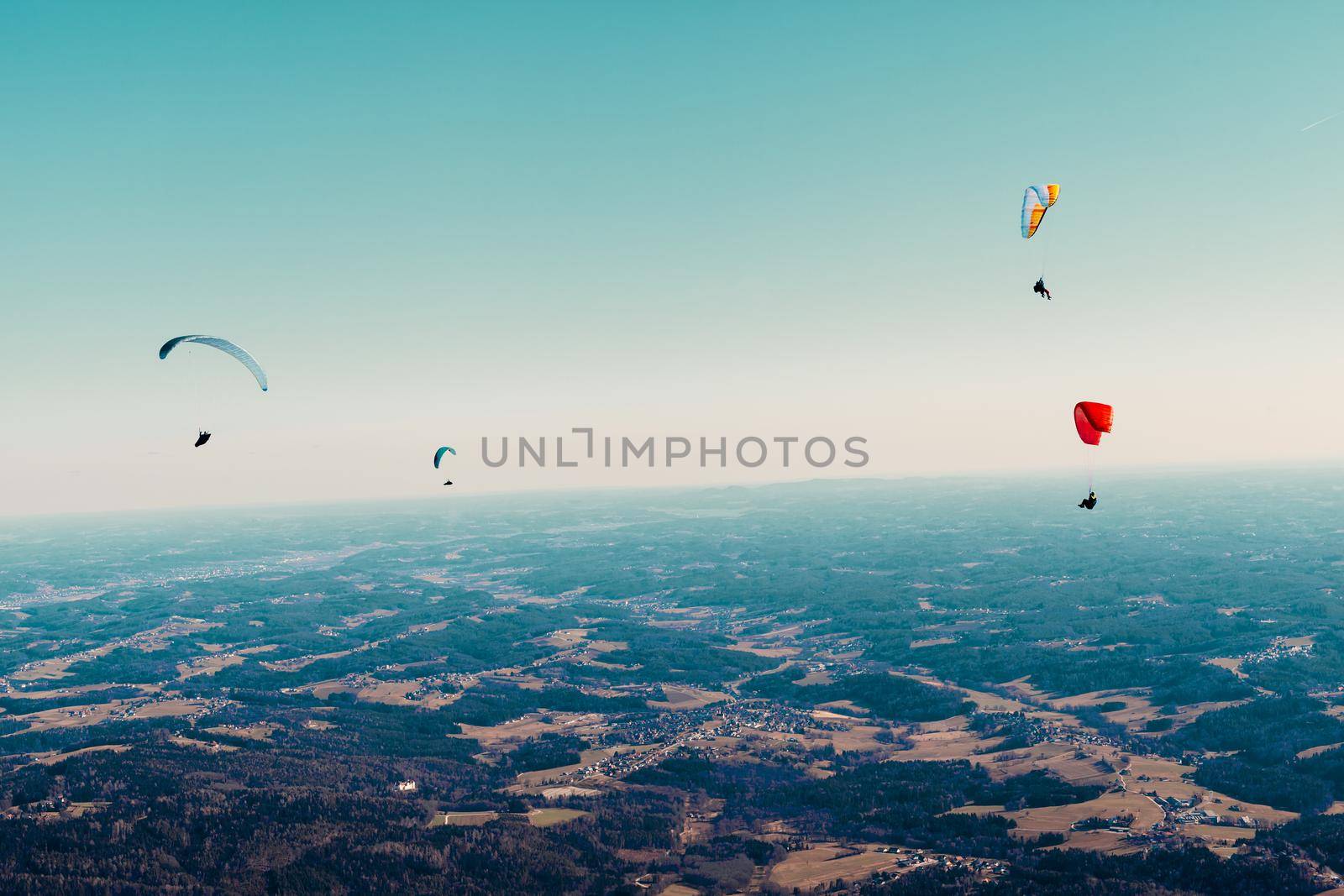 sports paragliding on a parachute over the countryside.