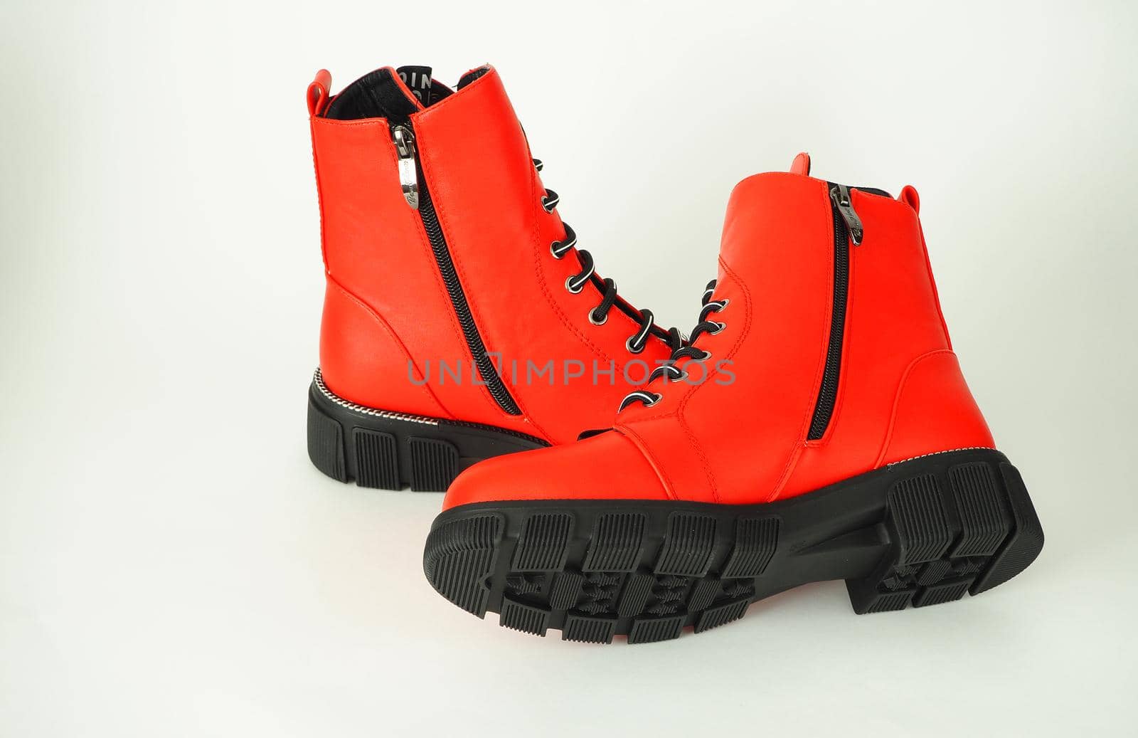 Fashionable womens shoes are red, with zipper and lacing, insulated on a white background. High quality photo