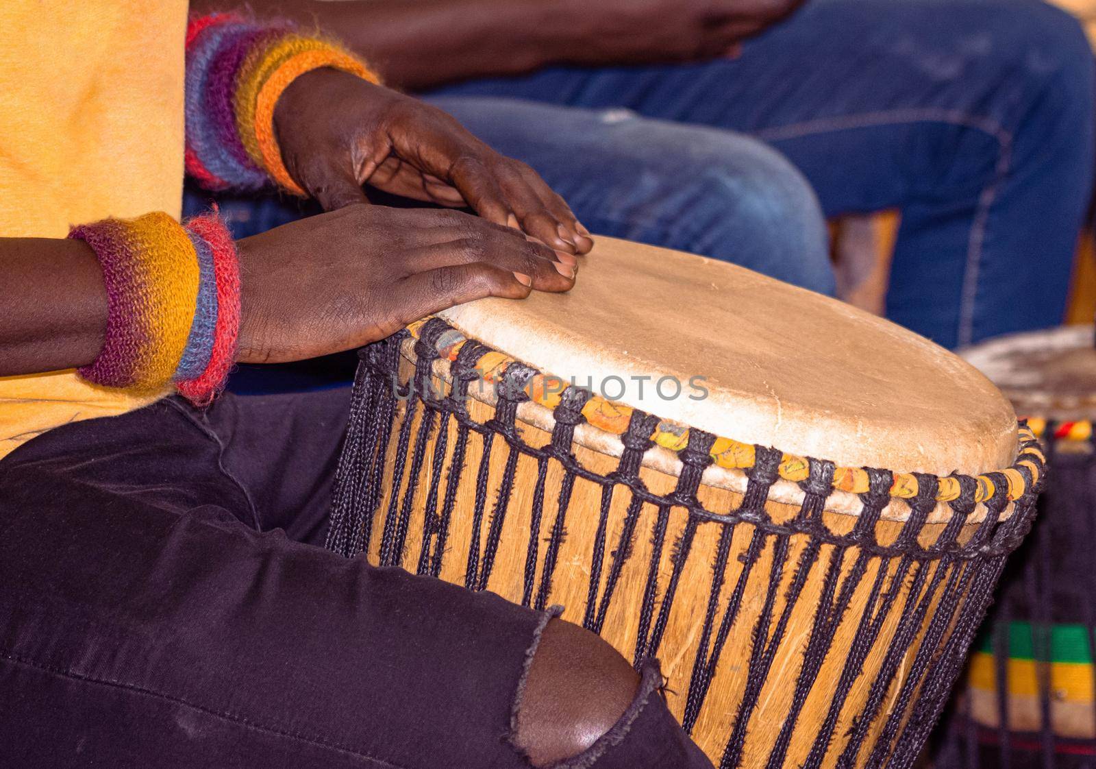 Close up of an African djembe drummer. Drummer playing African percussion music. Ethnic percussion musical instrument Djembe and male hands. Rhythm of Africa.