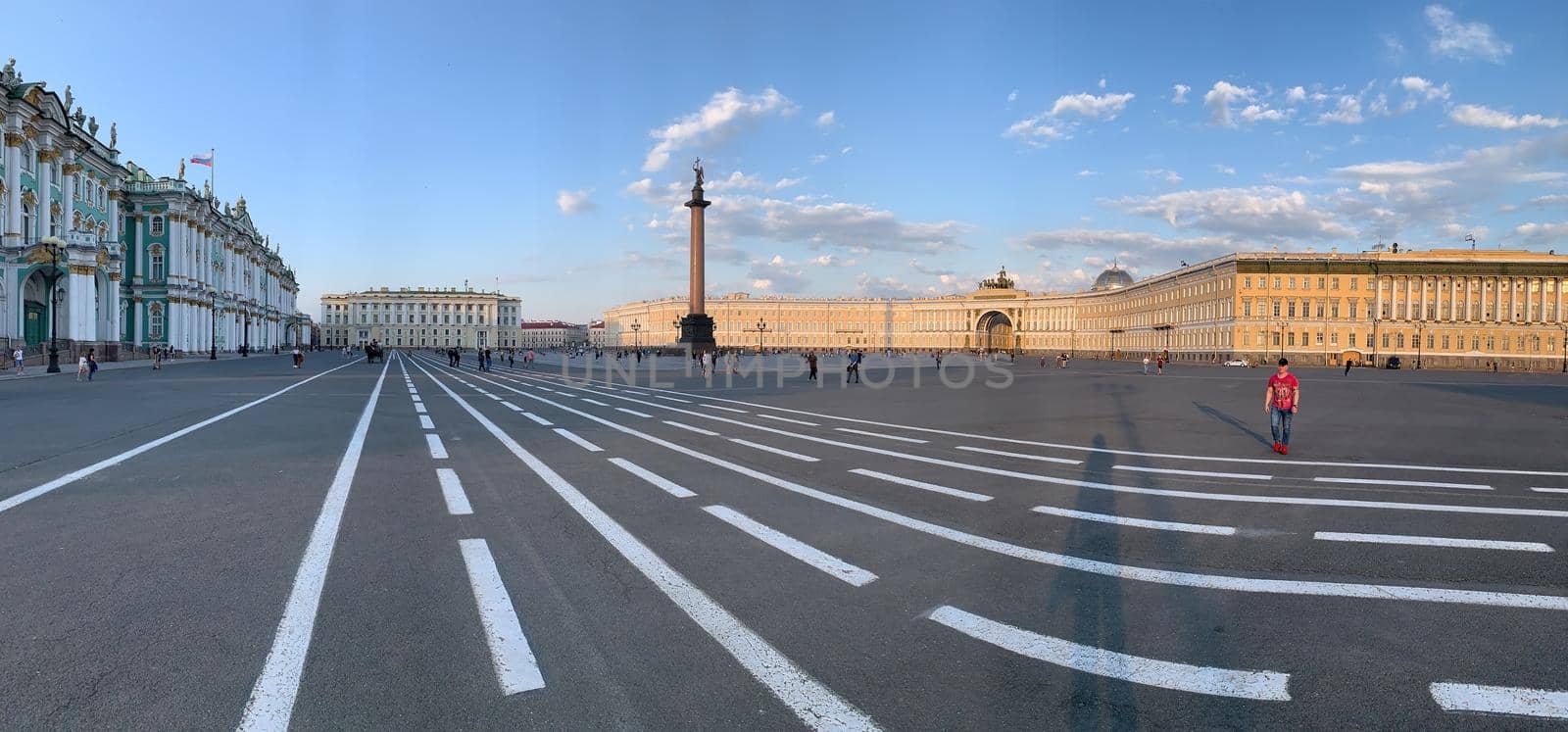 Russia, St.Petersburg, 09 June 2020: Specular panoramic image of the Palace square at sunset, residents walk across square, the Alexandria column on a background. High quality photo