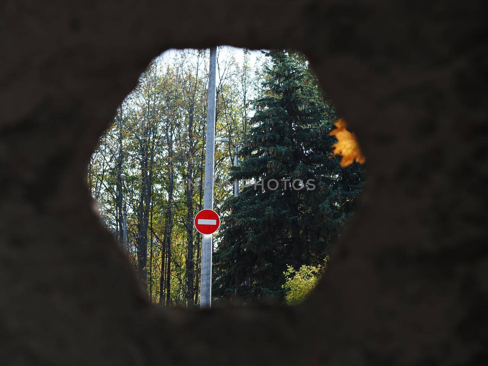 A protected object behind a concrete fence. Road sign Travel is forbidden.