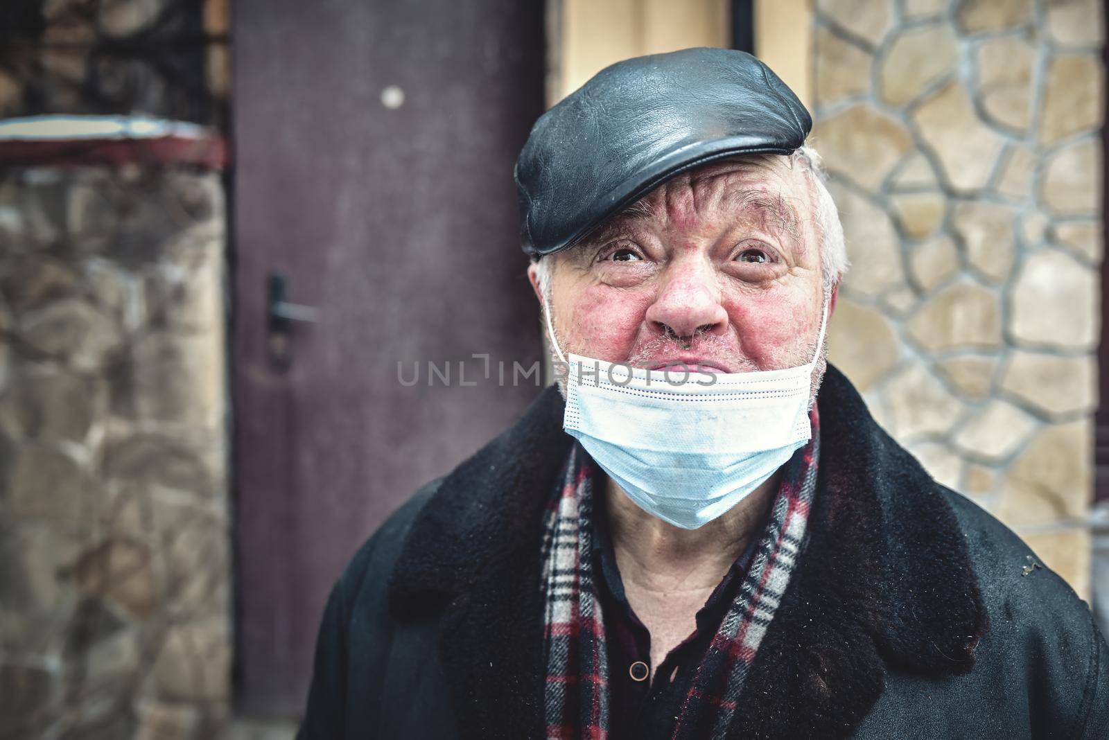 Kyiv. Ukraine - February 4: 2021 The cries of an injured homeless man wearing a protective mask, looking into a camera, feeling depressed in quarantine time in Kyiv. Ukraine - February 4 2021