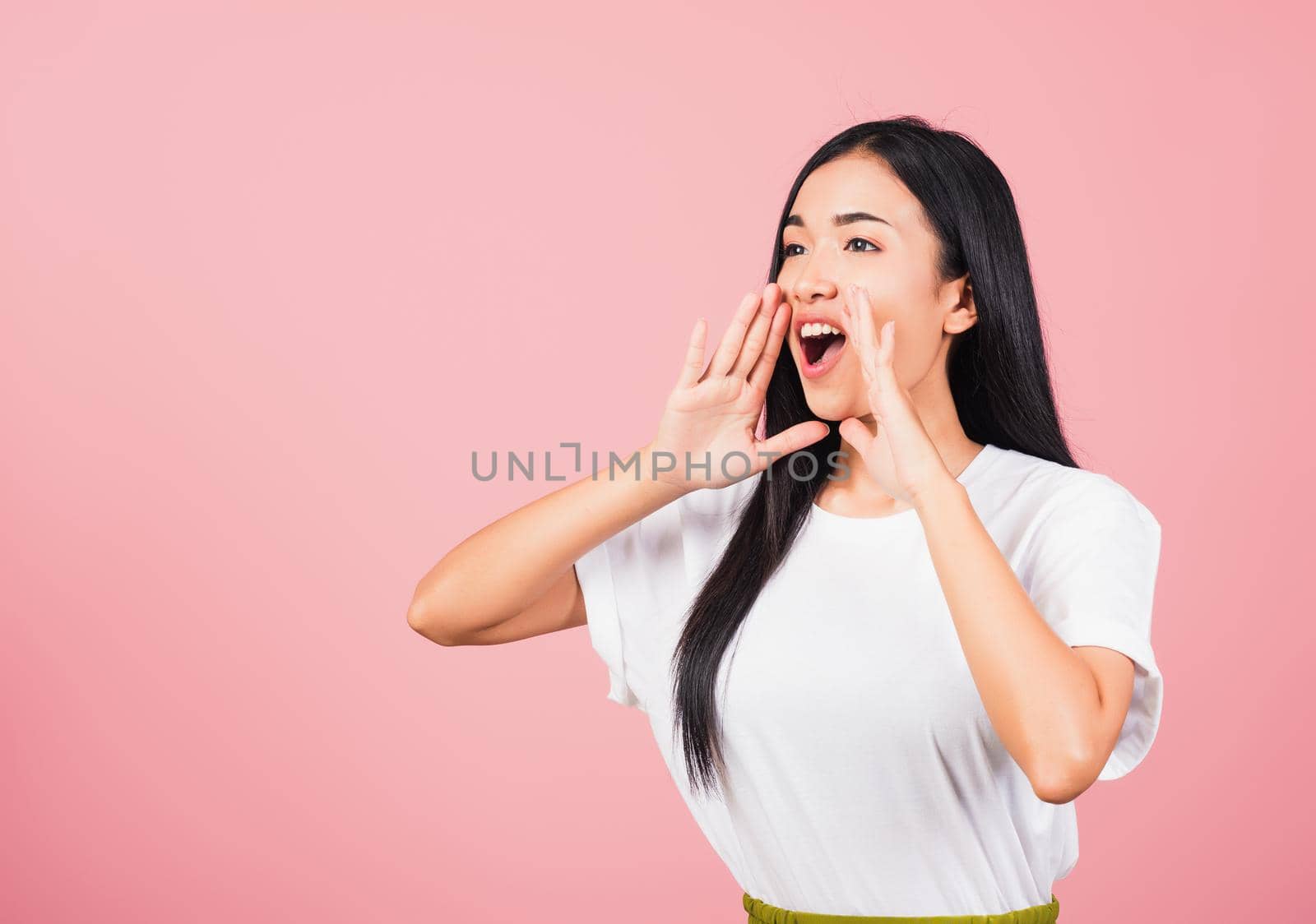 Asian happy portrait beautiful cute young woman teen standing hand on mouth talking news announcement studio shot isolated on pink background, Thai female looking to side away with copy space