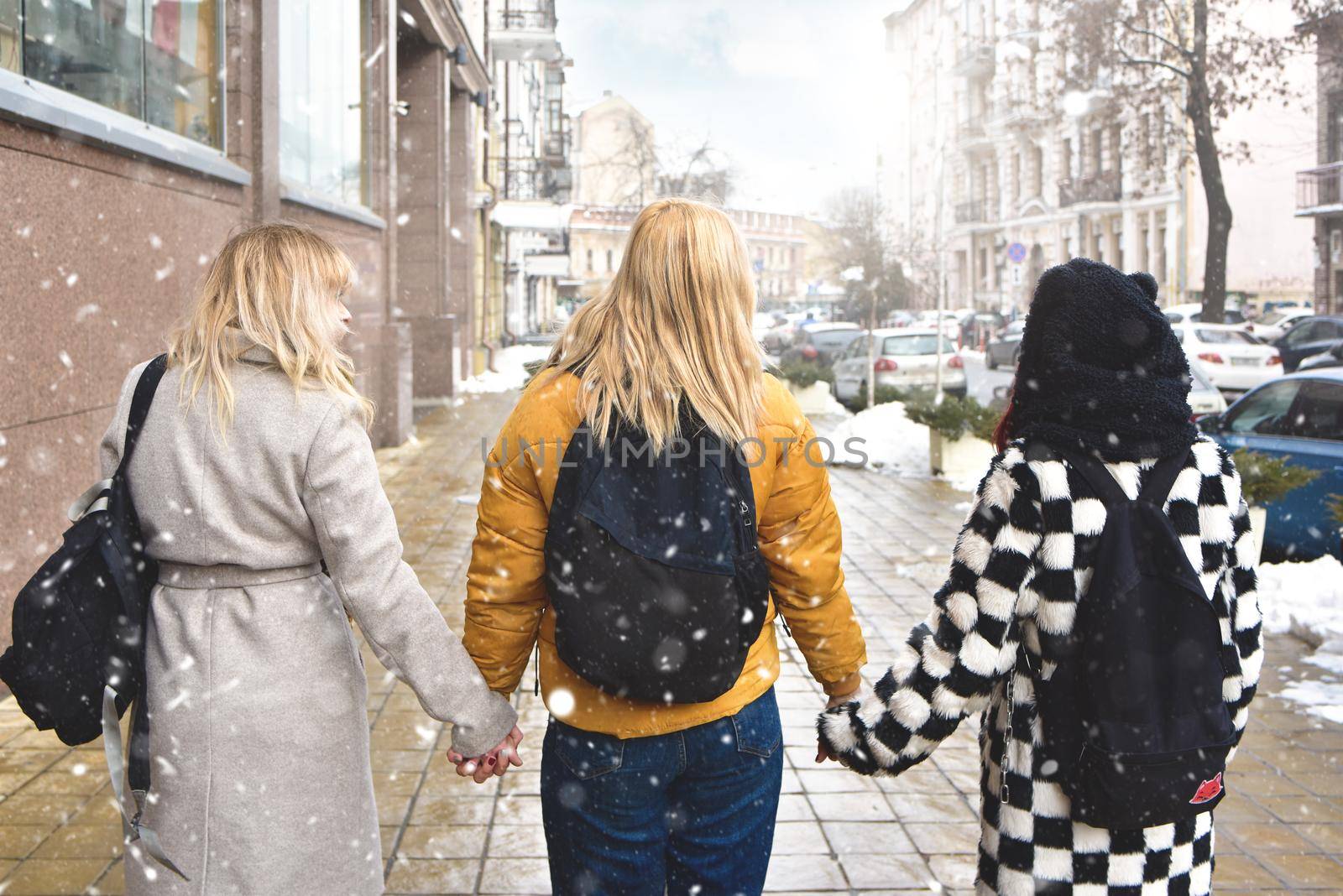 Three student girls walking in the school yard view from back . friendship concept by Nickstock