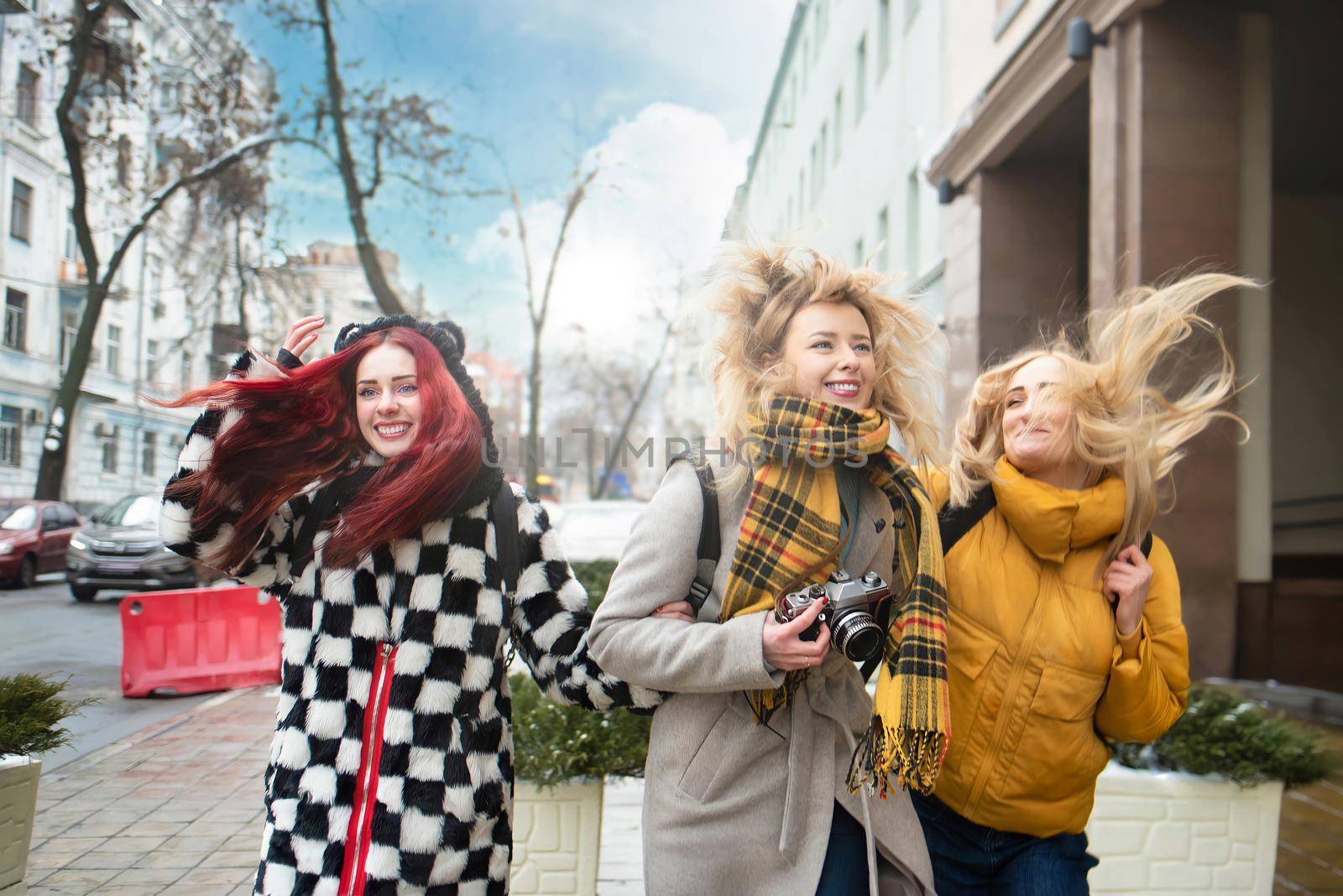 tourism concept - three beautiful girls tourists, having fun Running through the bright city by Nickstock