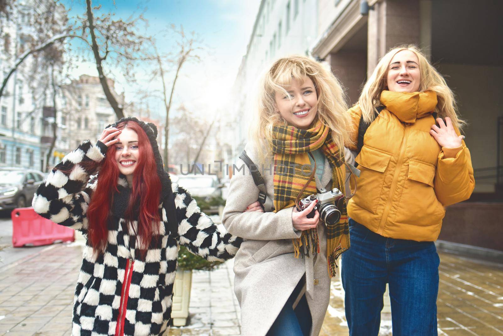 tourism concept - three beautiful girls tourists, having fun Running through the bright city by Nickstock