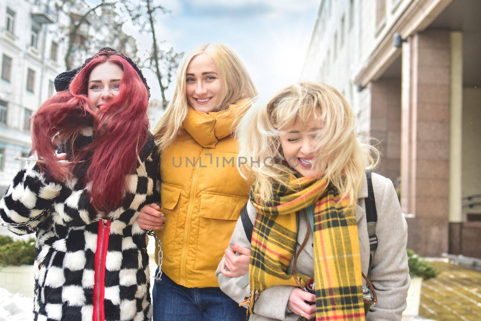tourism concept - three beautiful girls tourists, having fun Running through the bright city by Nickstock