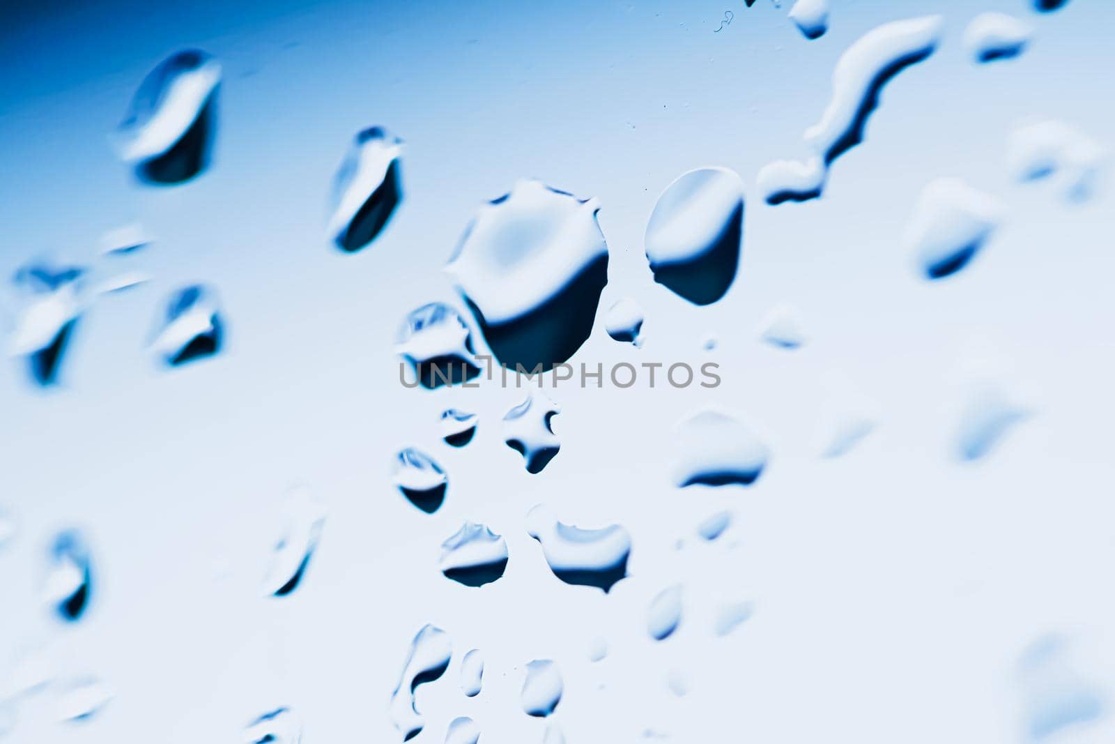 Liquid water drops on glass surface, abstract backdrop and science background by Anneleven