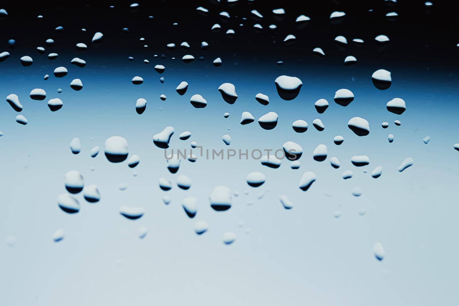 Liquid water drops on glass surface, abstract backdrop and science background concept