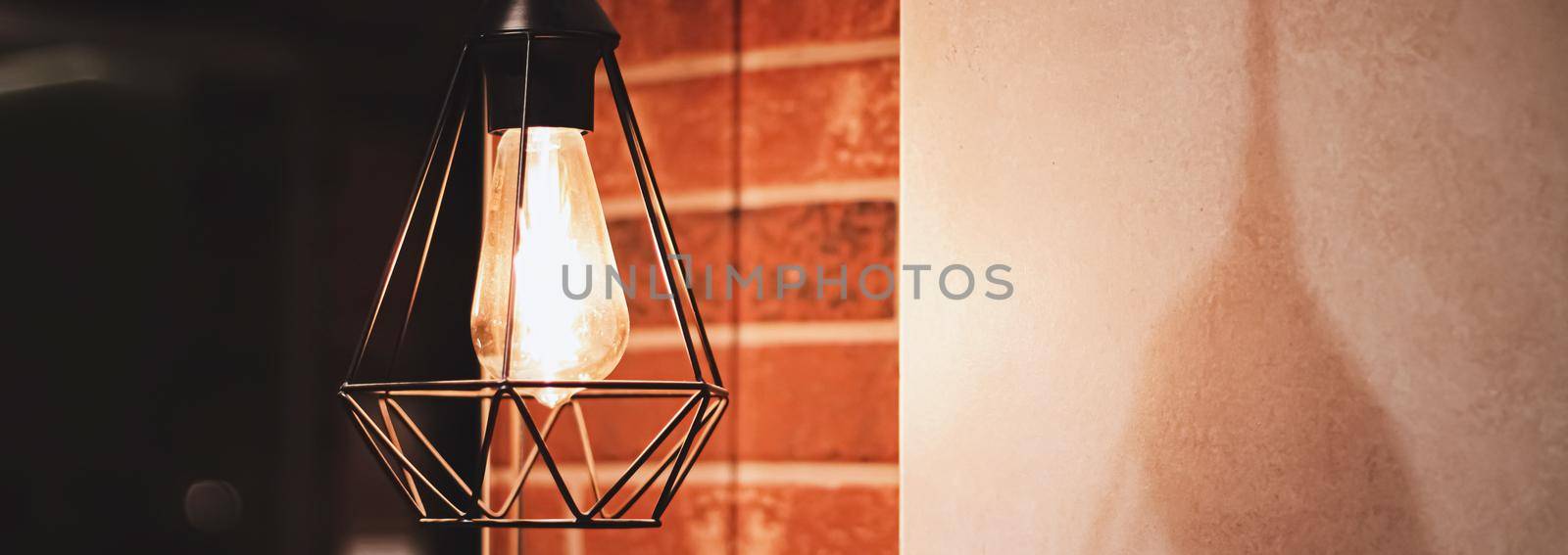 Pendant industrial lamps in loft interior with dark brick walls, modern design and home decor concept