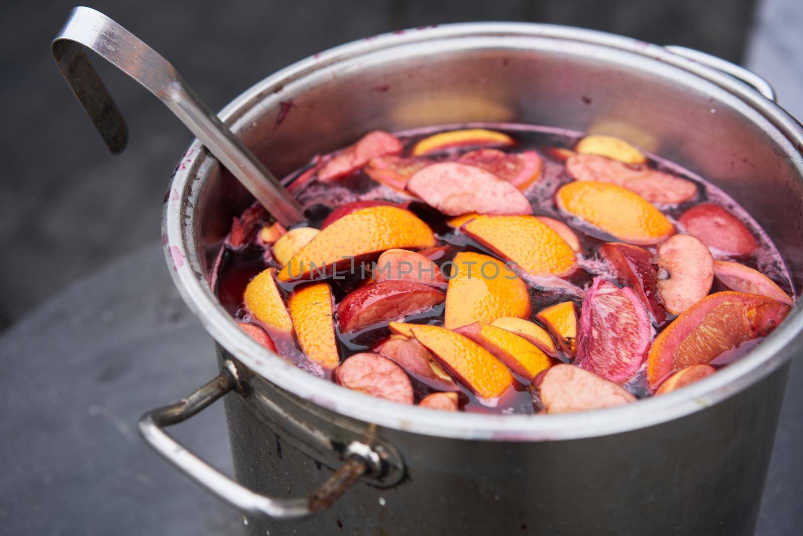 closeup of mulled wine, preparing in big old metal kettle on fire, above view, Traditional Christmas fair market beverage