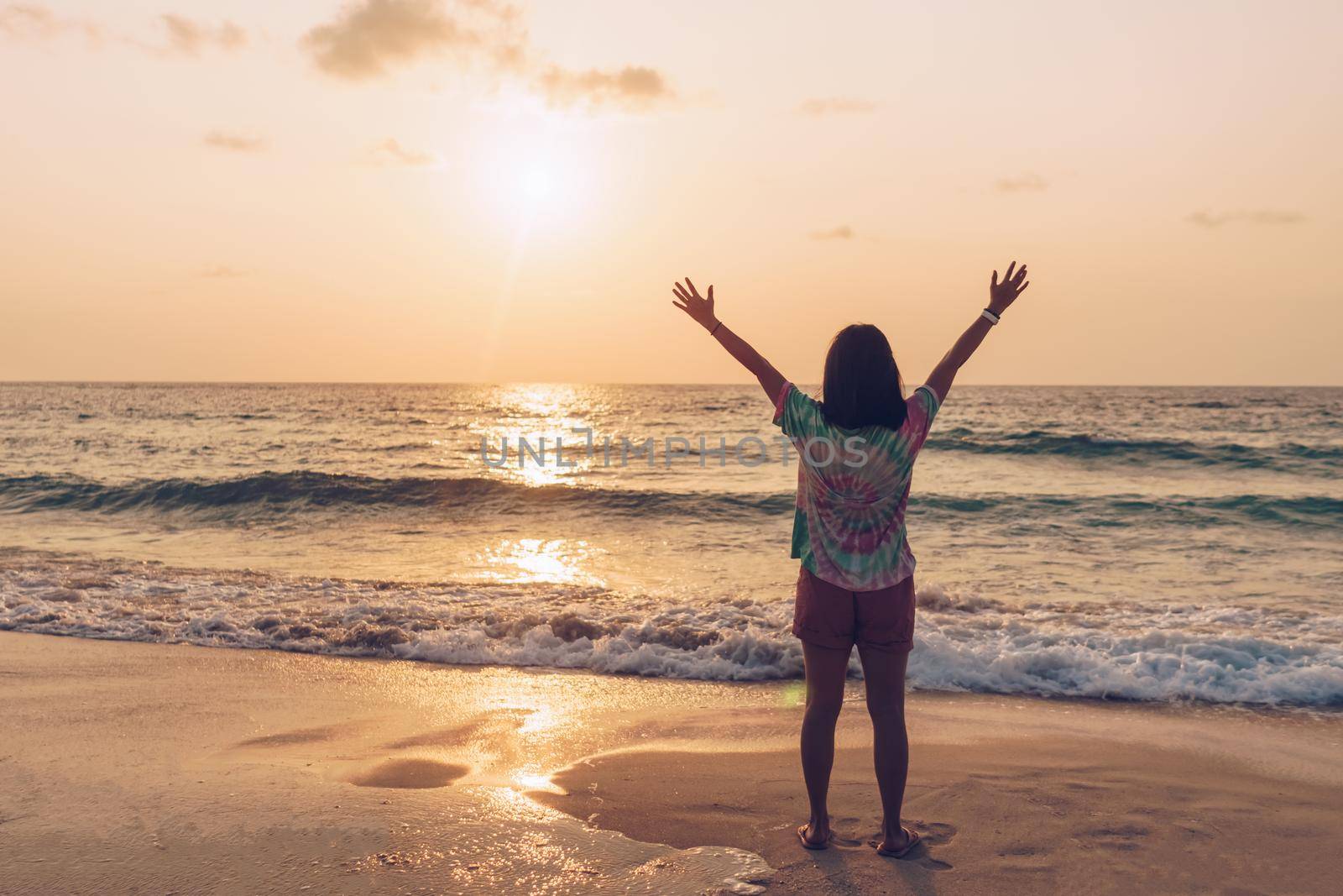 Woman rise hands up to sky travel around the world with summer beach freedom. by Suwant