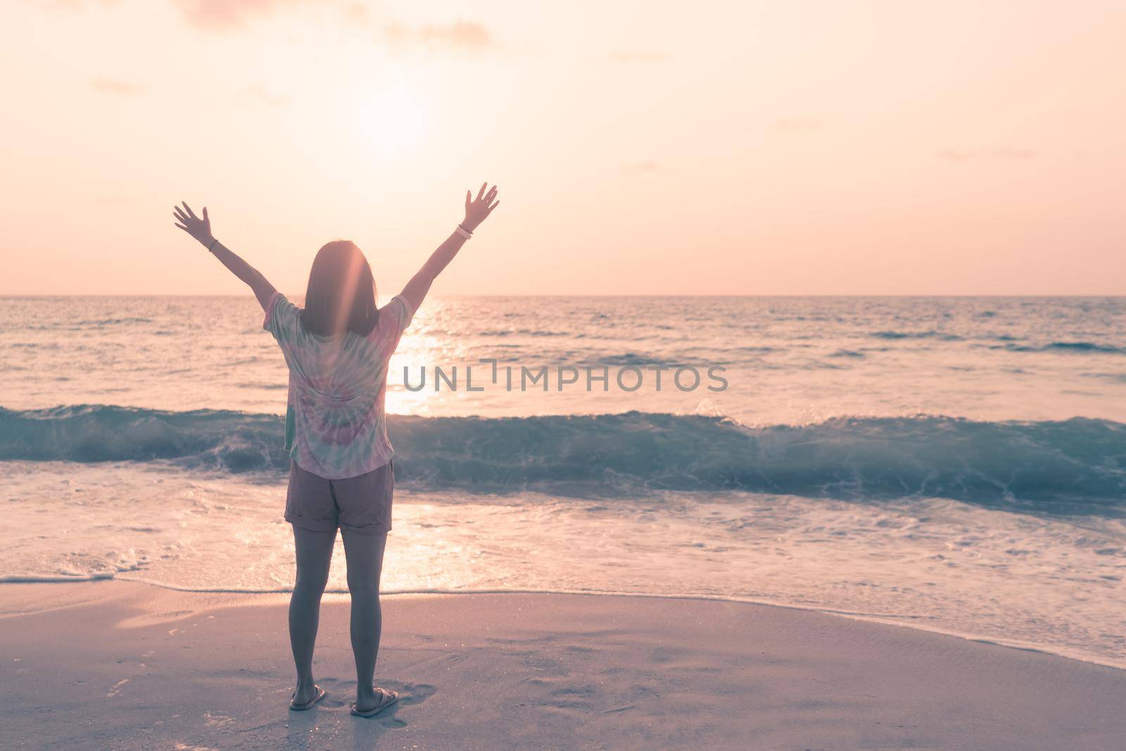 Woman rise hands up to sky travel around the world with summer beach freedom and relax life.