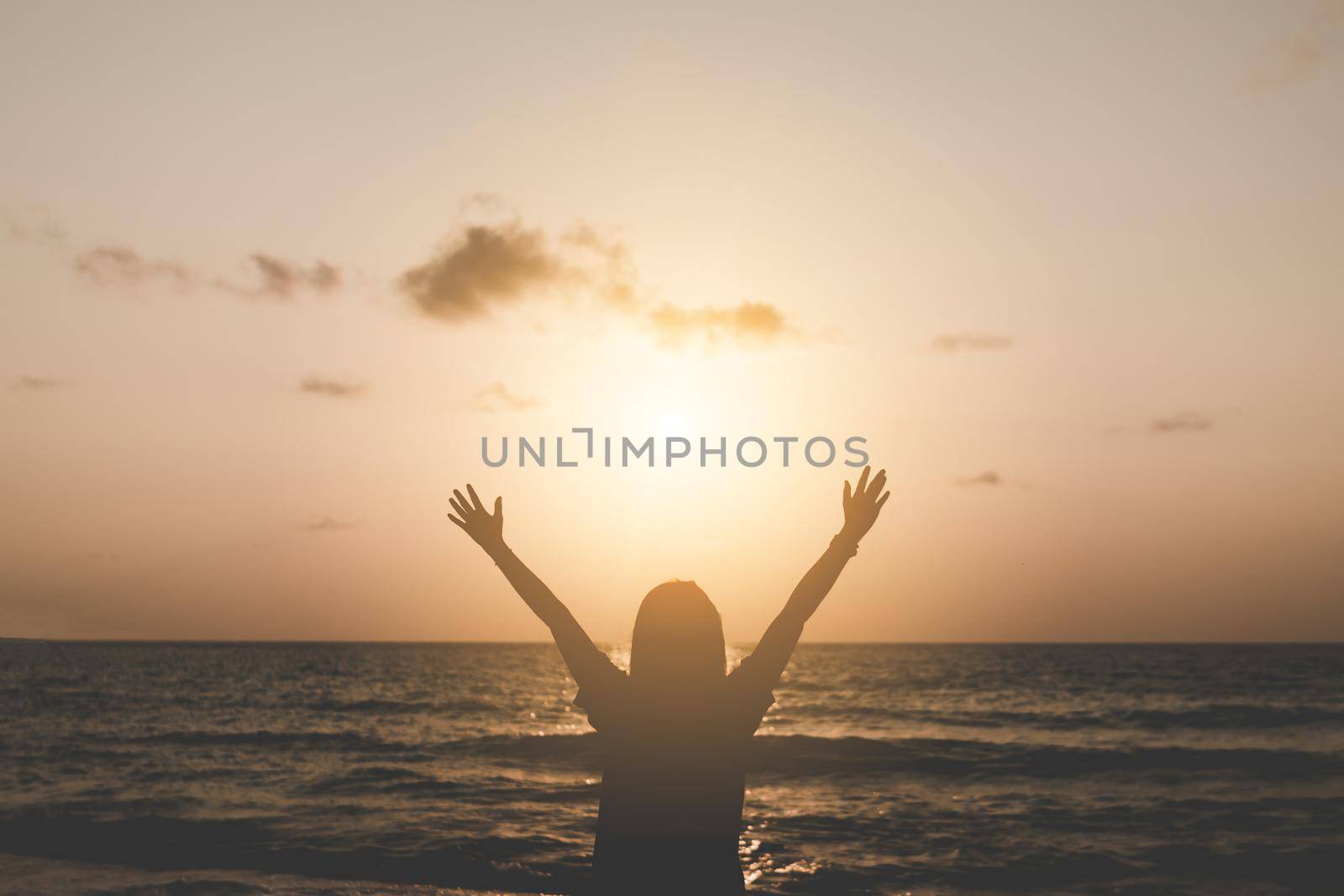 Woman rise hands up to sky travel around the world with summer beach freedom. by Suwant