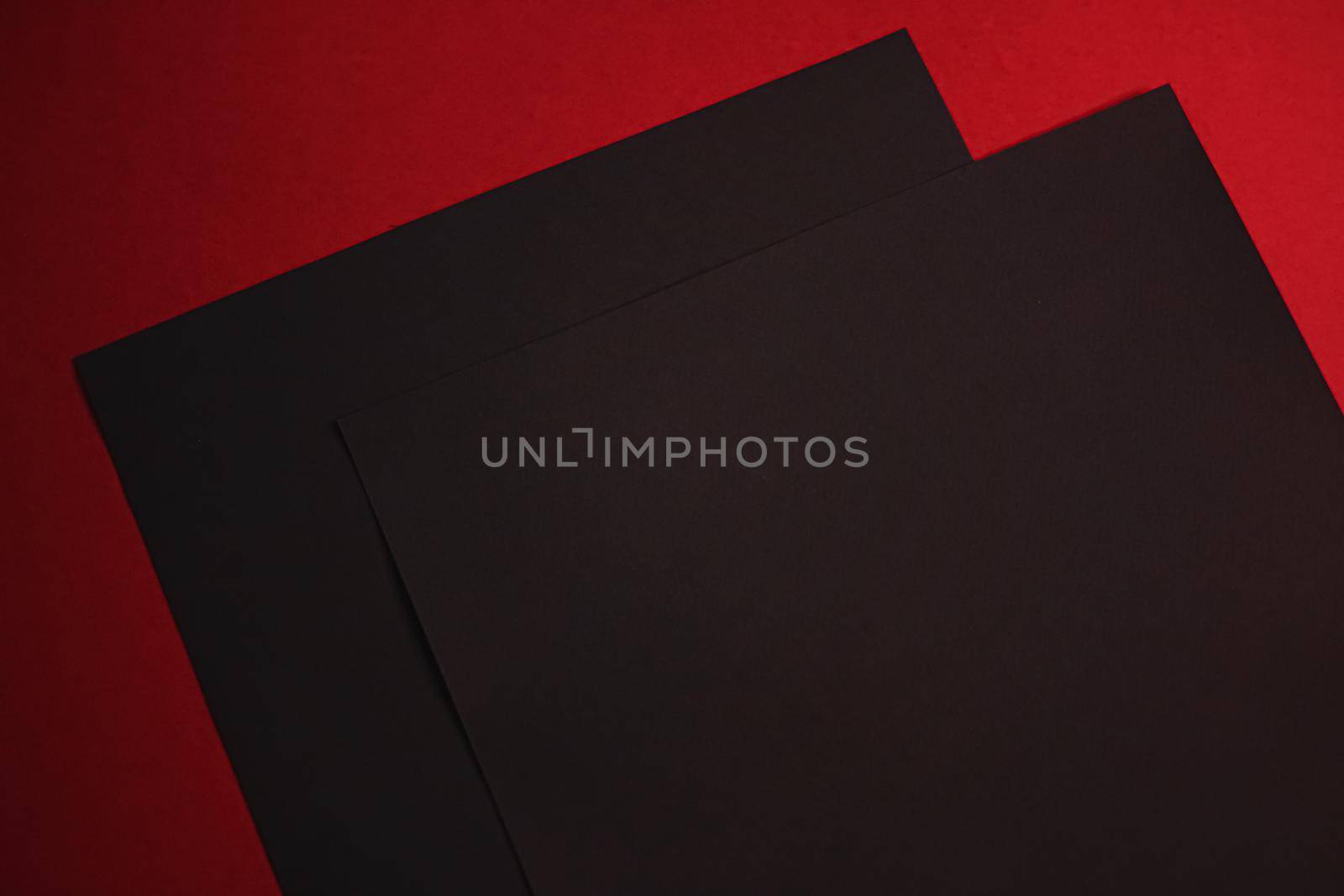 Black A4 papers on red background as office stationery flatlay, luxury branding flat lay and brand identity design for mockups