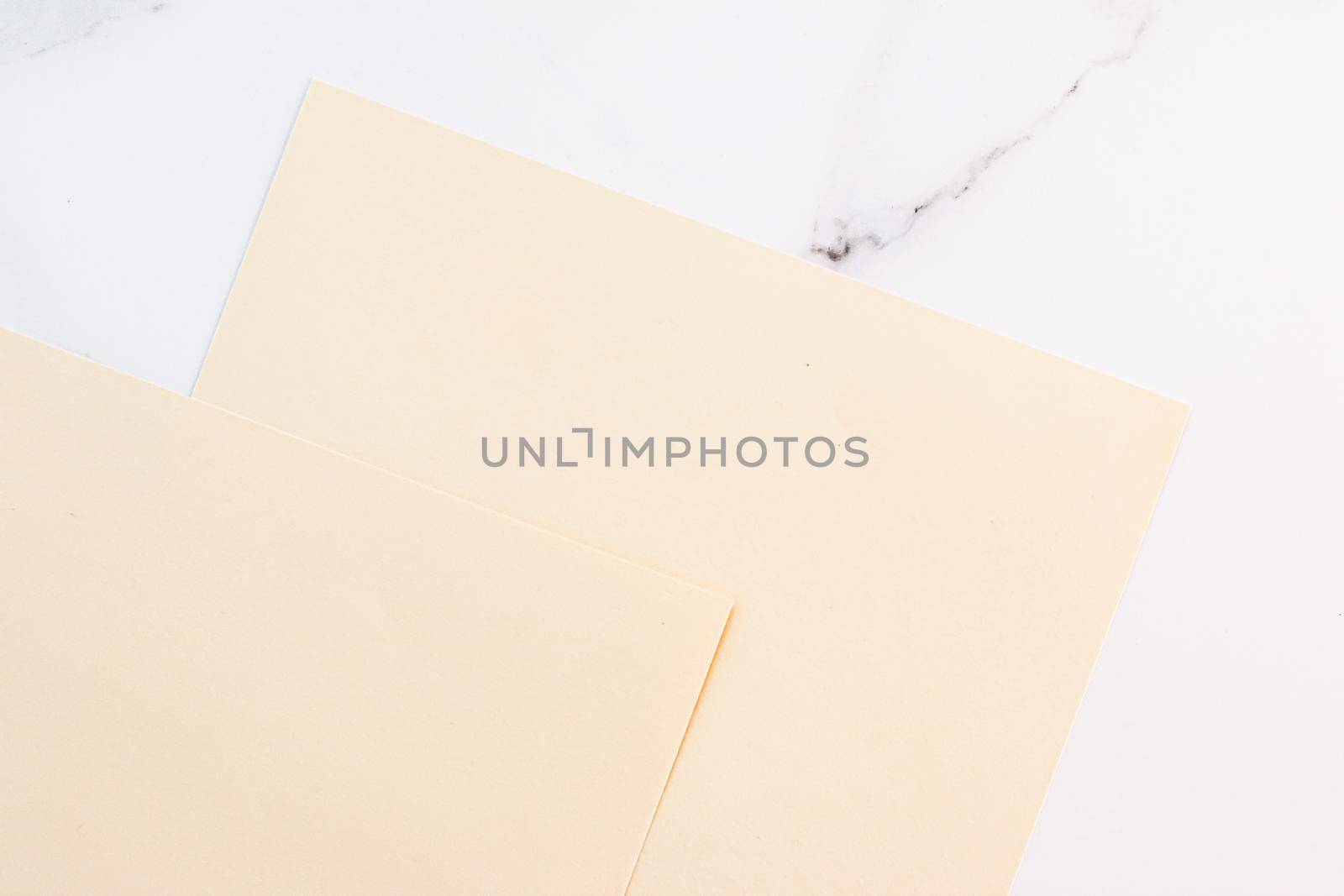 Beige A4 papers on white marble background as office stationery flatlay, luxury branding flat lay and brand identity design for mockup by Anneleven