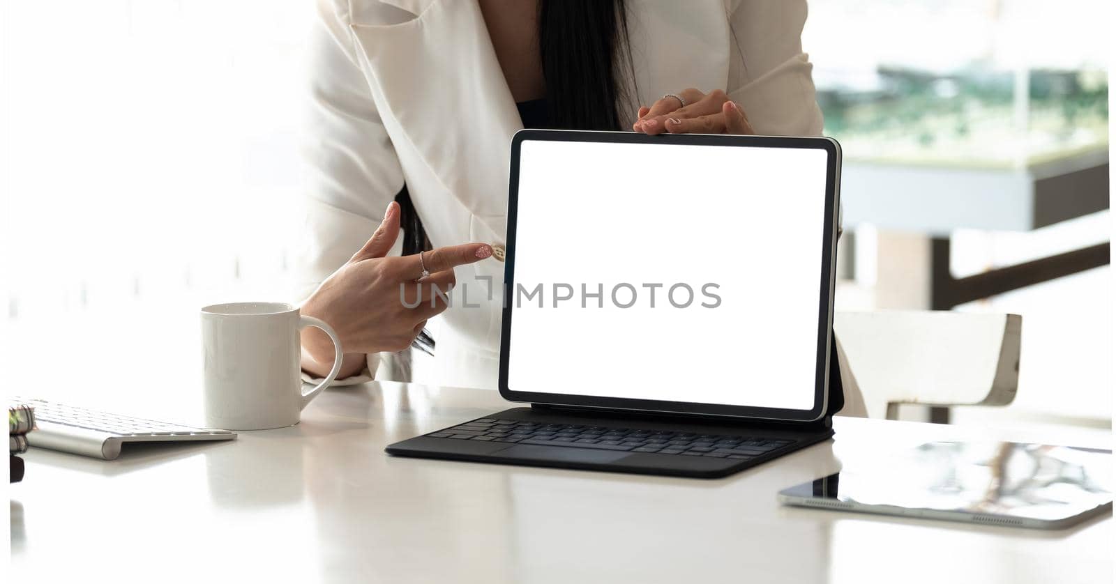 Businesswoman shows the laptop with blank screen in a front view shot