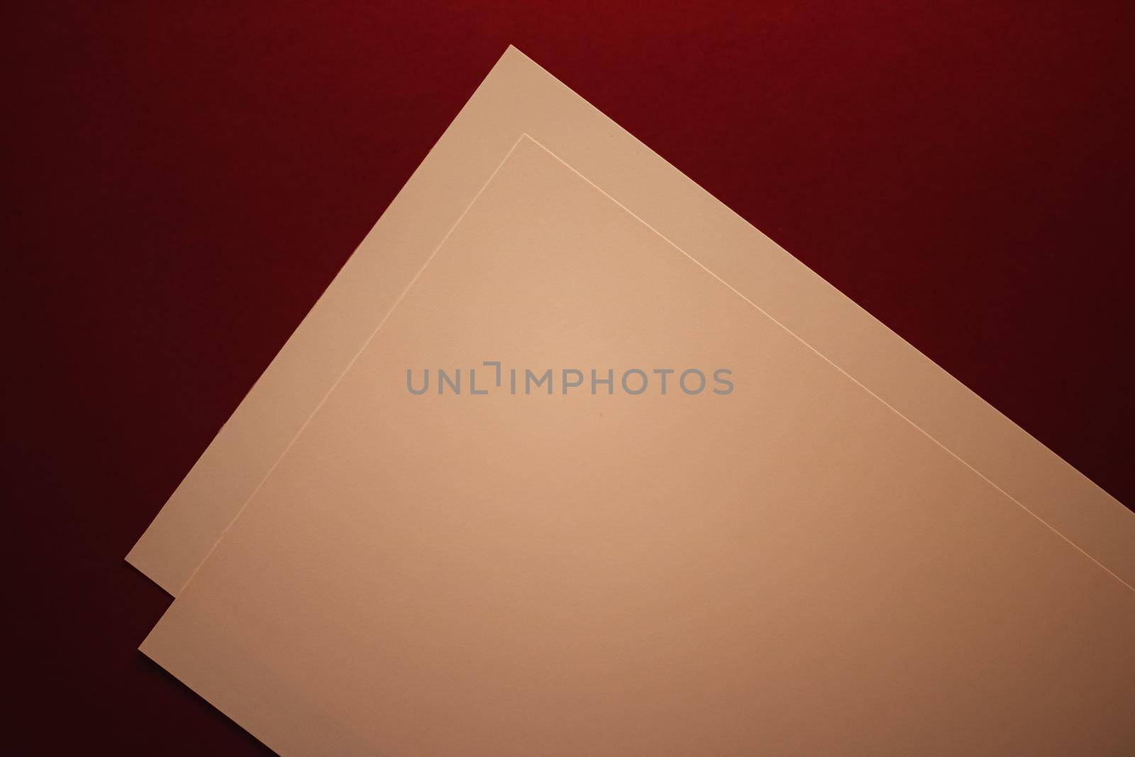 Beige A4 papers on dark red background as office stationery flatlay, luxury branding flat lay and brand identity design for mockup by Anneleven