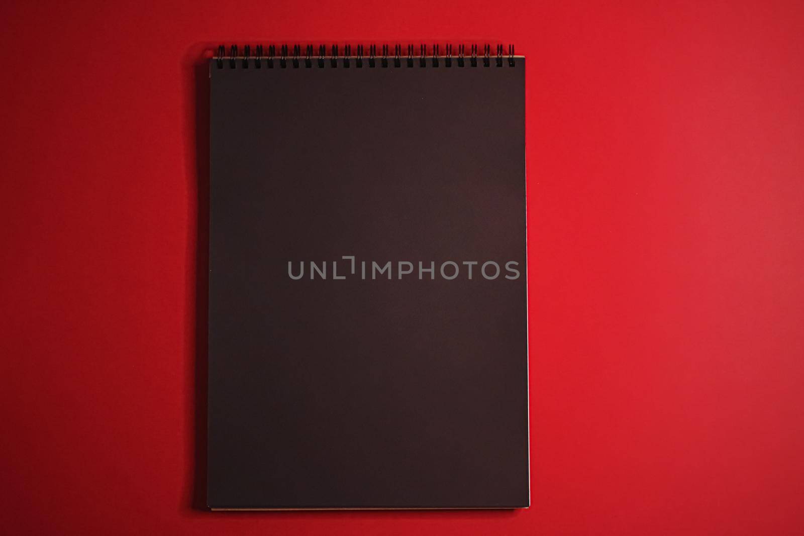 Black notebook on red background as office stationery flatlay, luxury branding flat lay and brand identity design for mockup by Anneleven